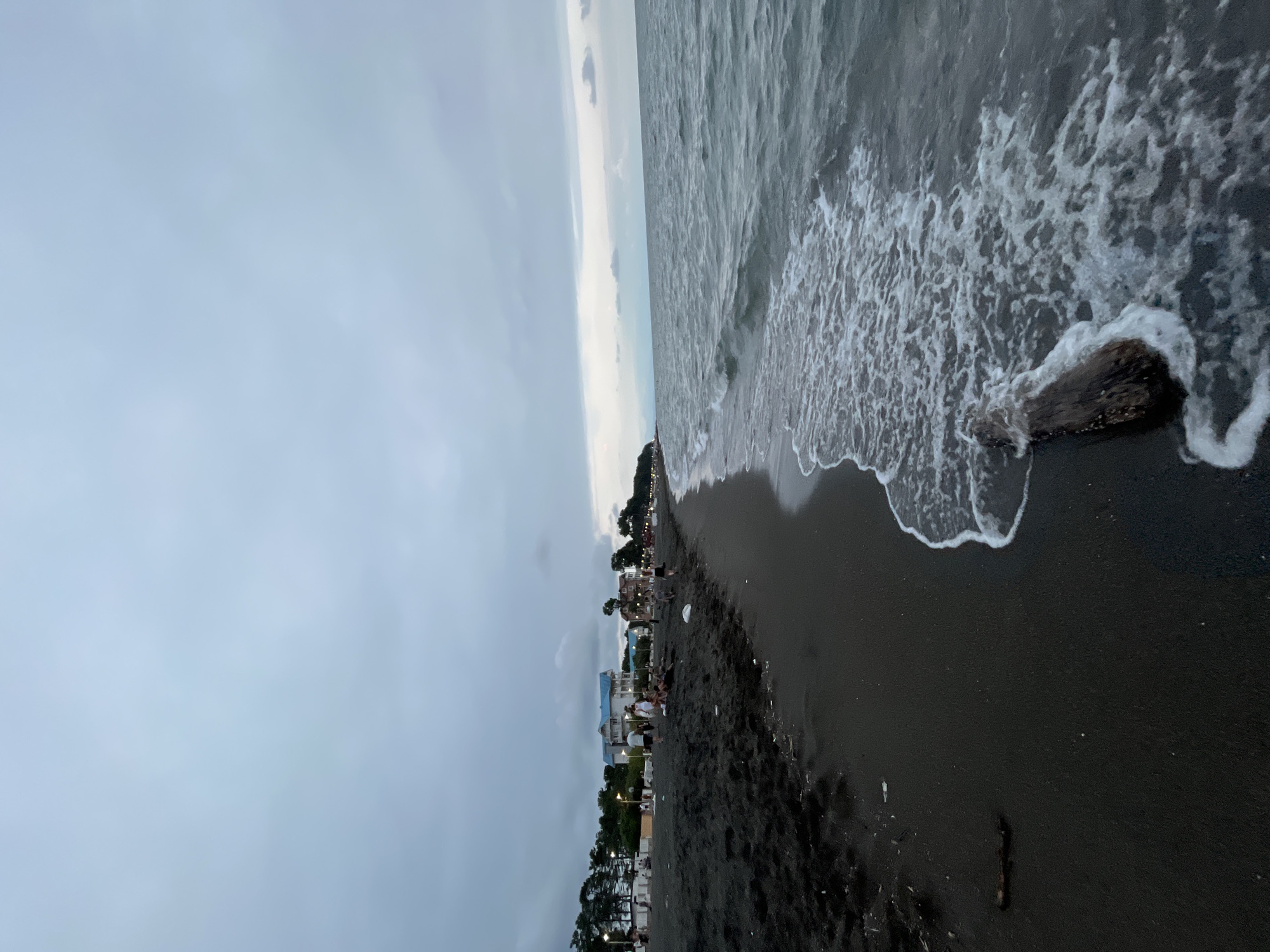 Overcast afternoon on Ureki's black sand beach and promenade
