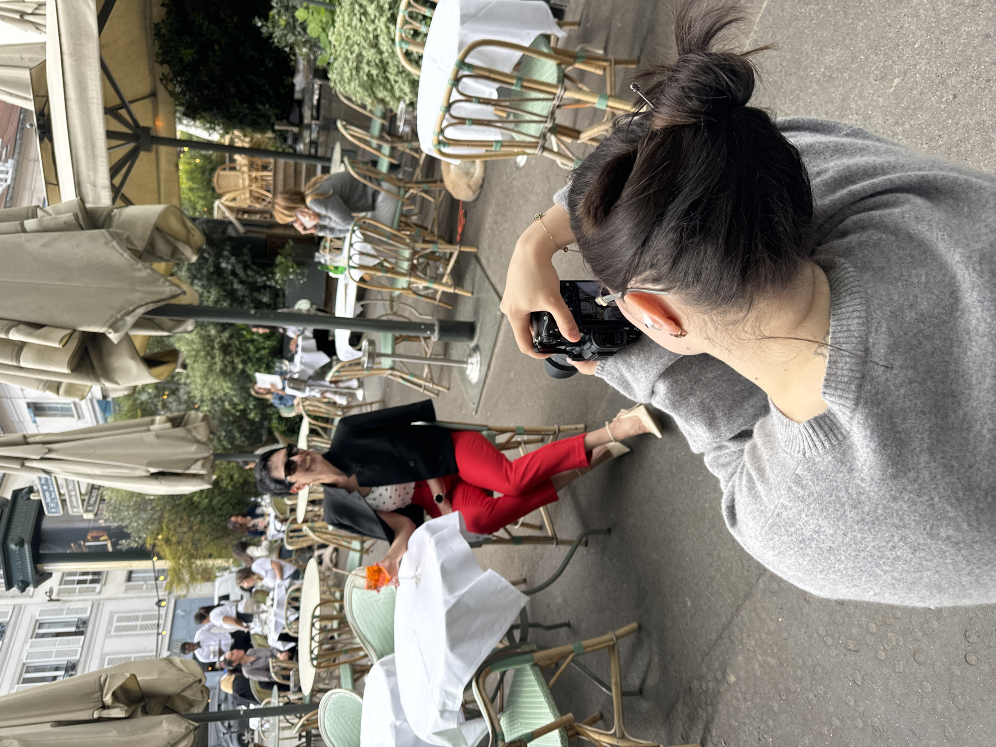 Woman poses for photos at Paris cafe
