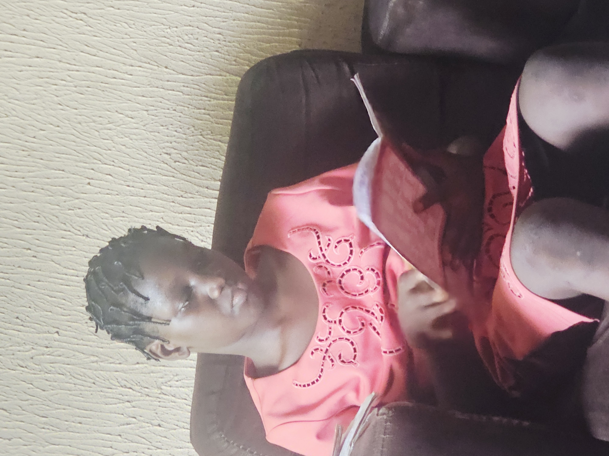 Young person reading book in chair, Nkwelle Nigeria