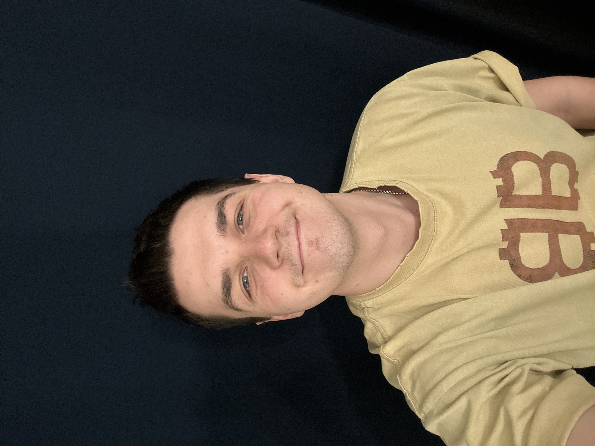 Young man poses for photo in yellow BB shirt