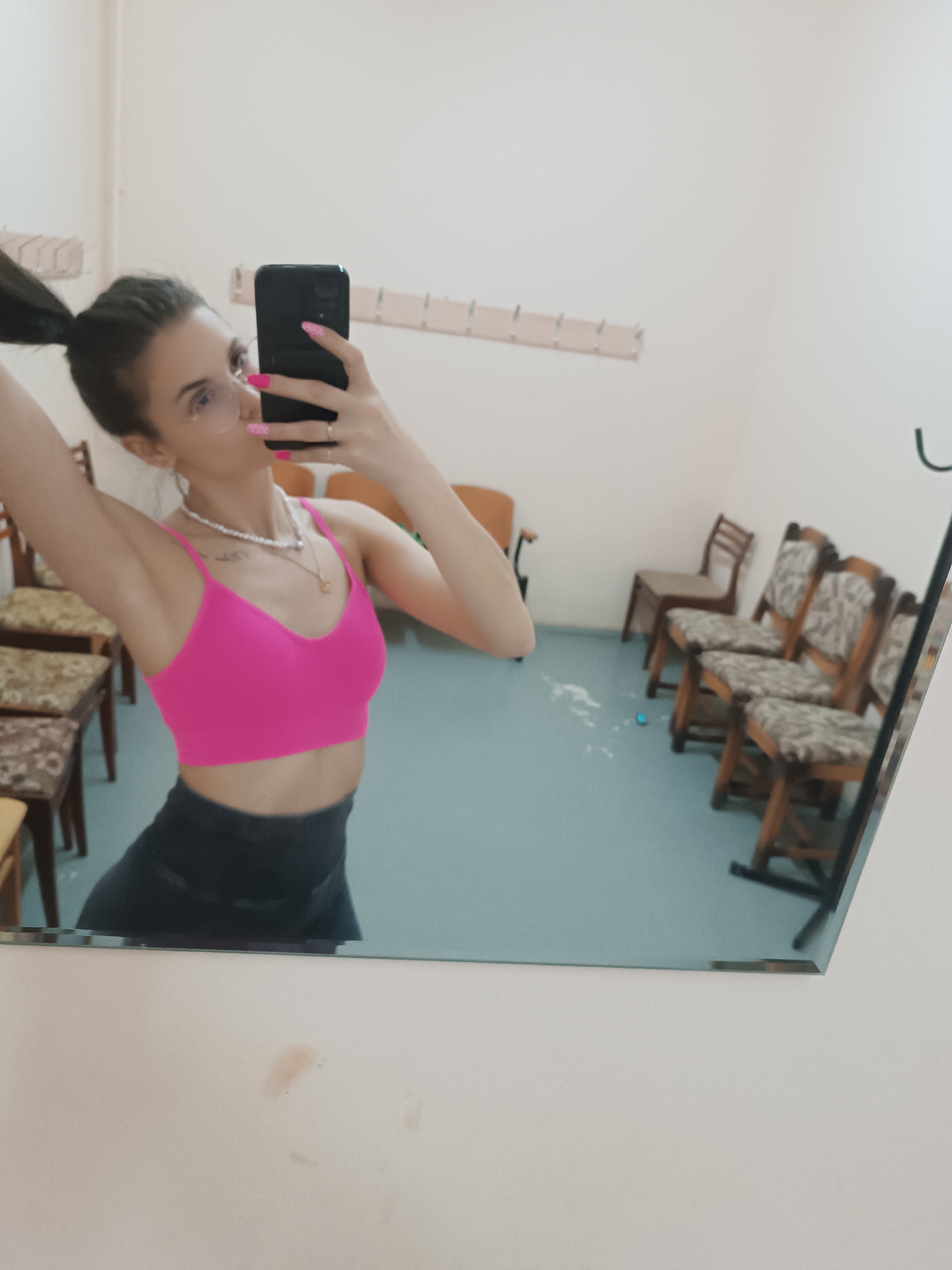 Person takes mirror selfie in waiting room wearing athletic wear