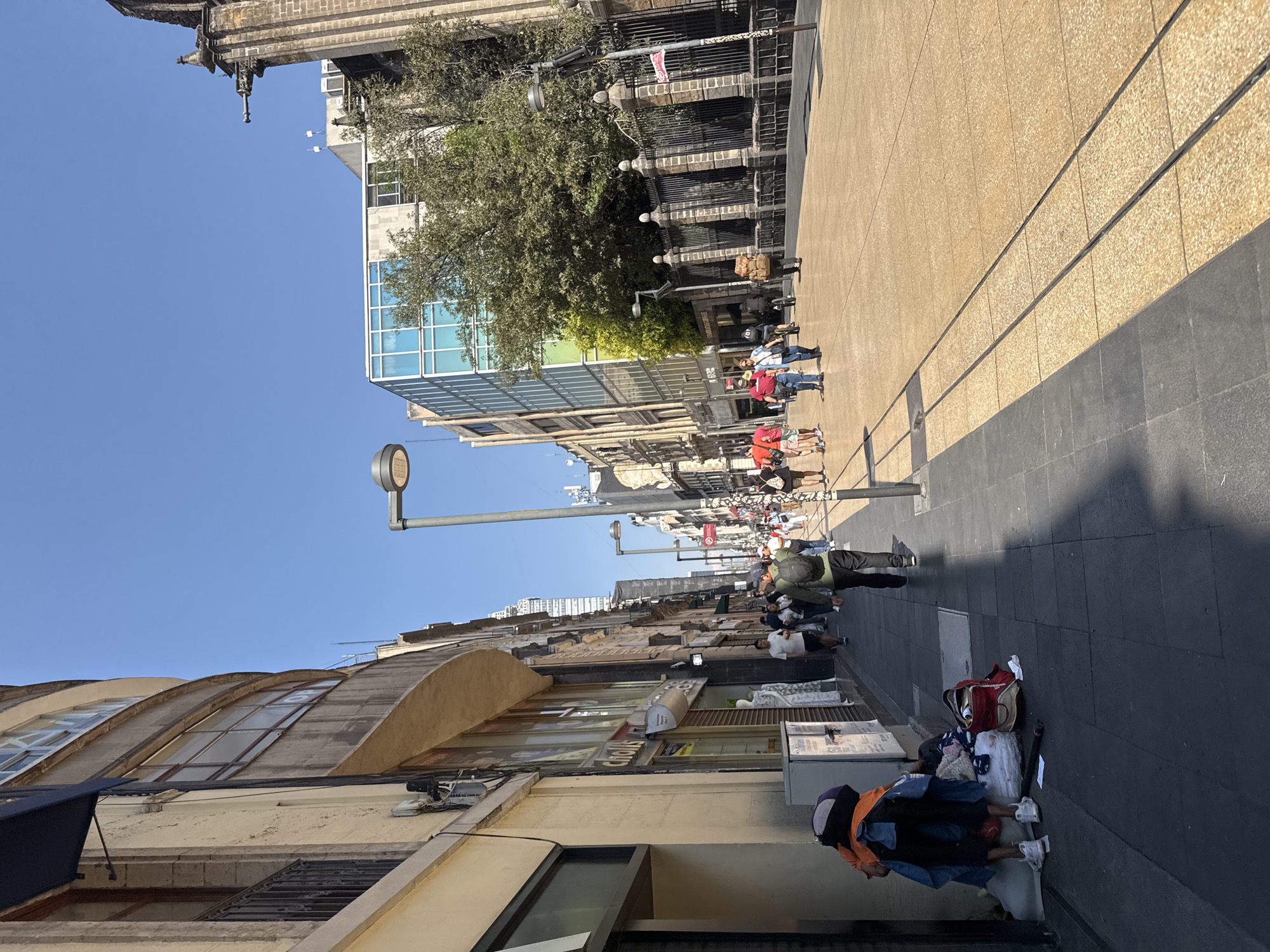 Pedestrians stroll through Mexico City walkways amid varied architecture