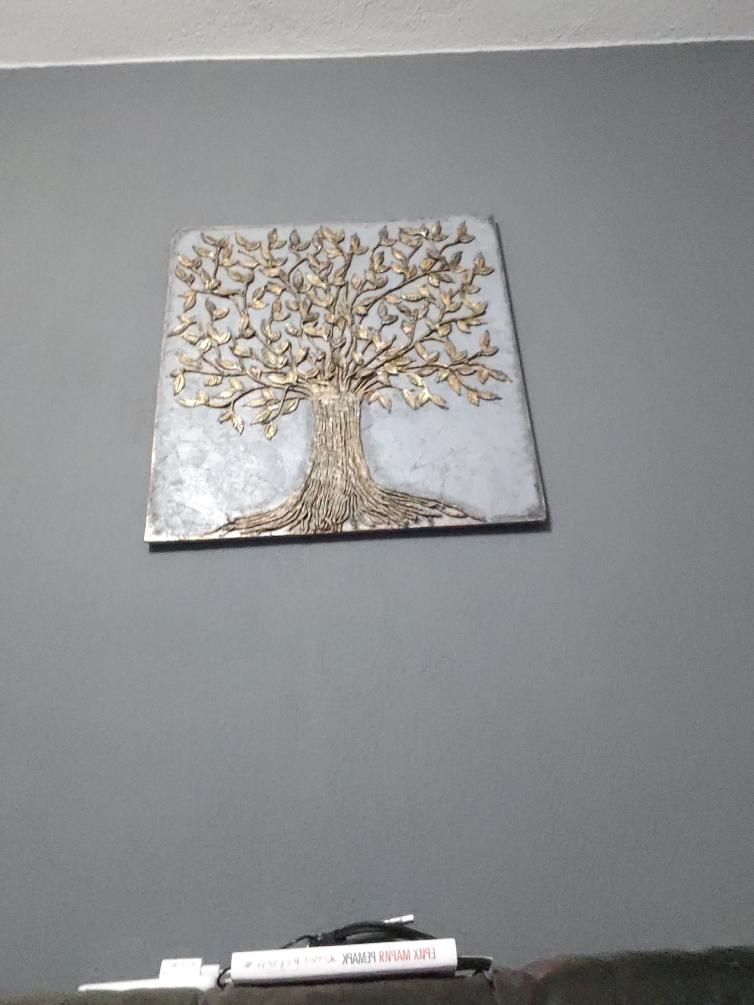 Tree of life artwork observed on wall with electronic device