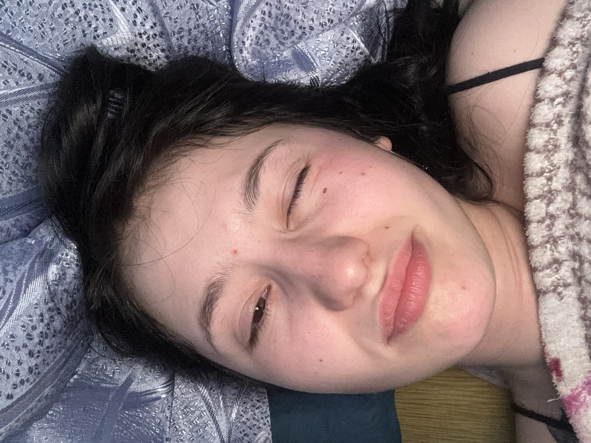 Woman resting on bed observed in Фоки, Russia