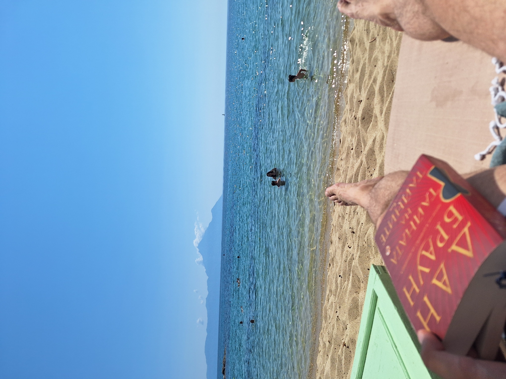 Lazy beach morning in Toroni, Greece — book, umbrella, calm sea.
