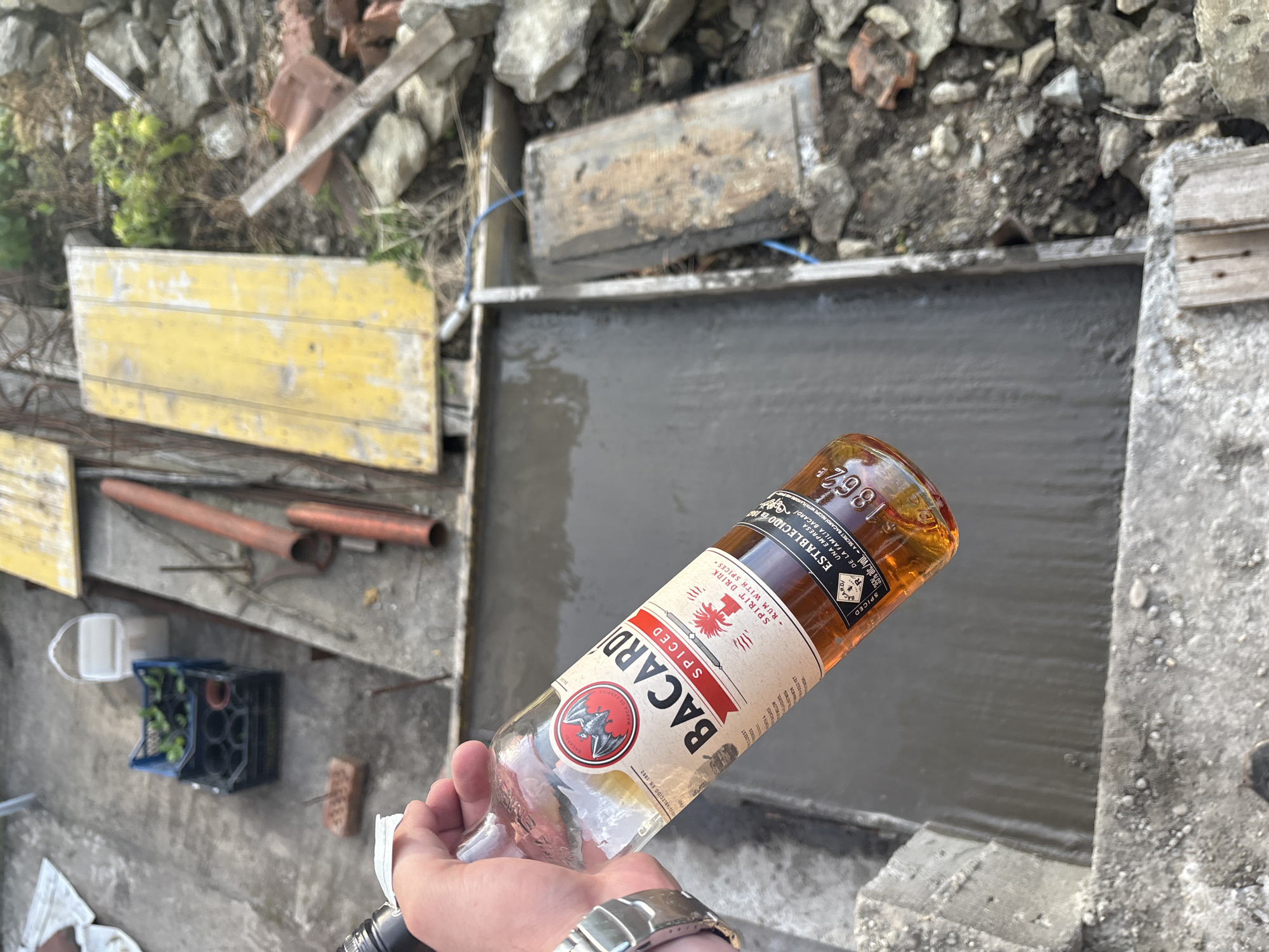 Person drinks Bacardi rum at construction site