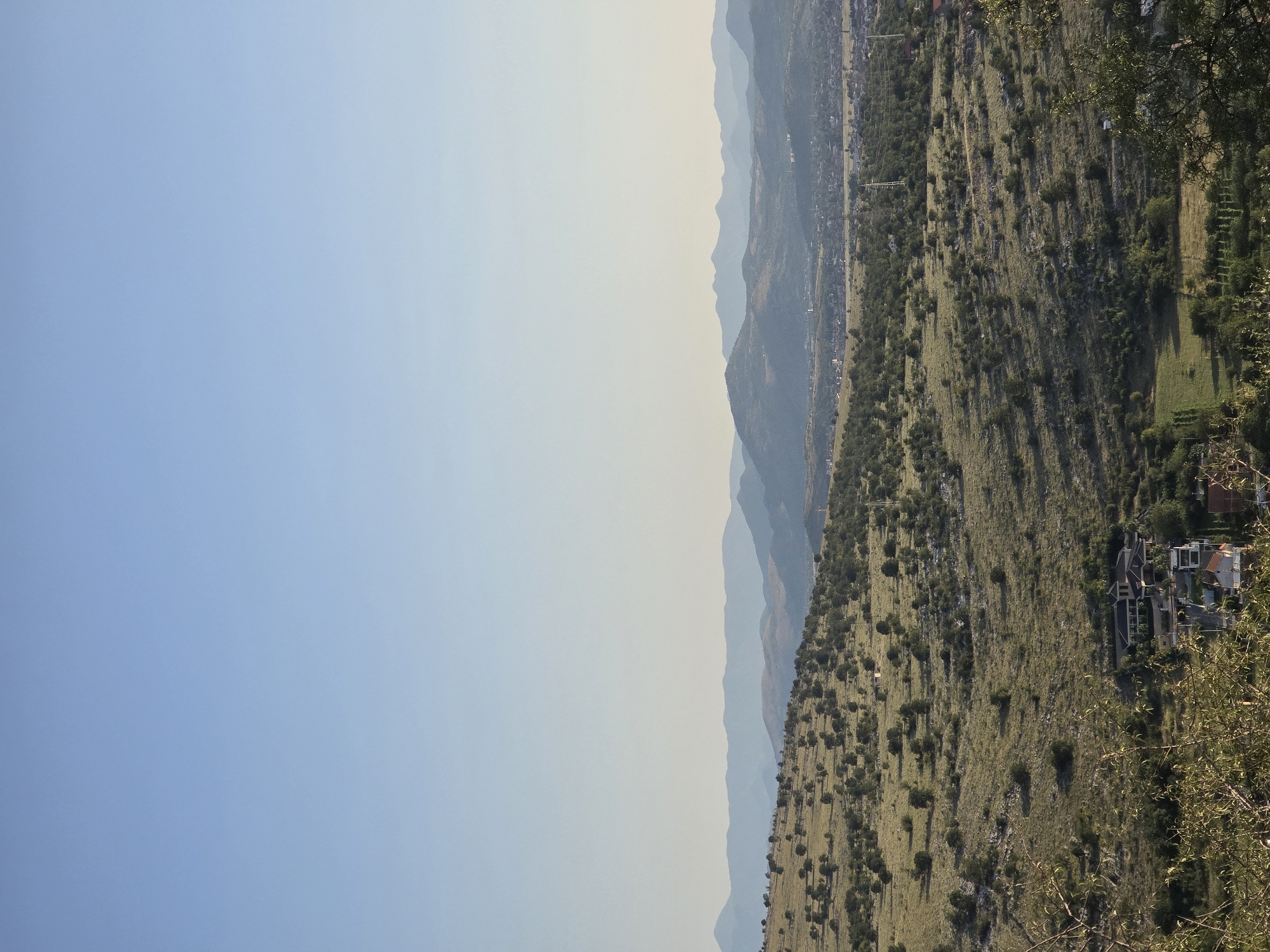 Hilly landscape with monuments, flags, and rural infrastructure