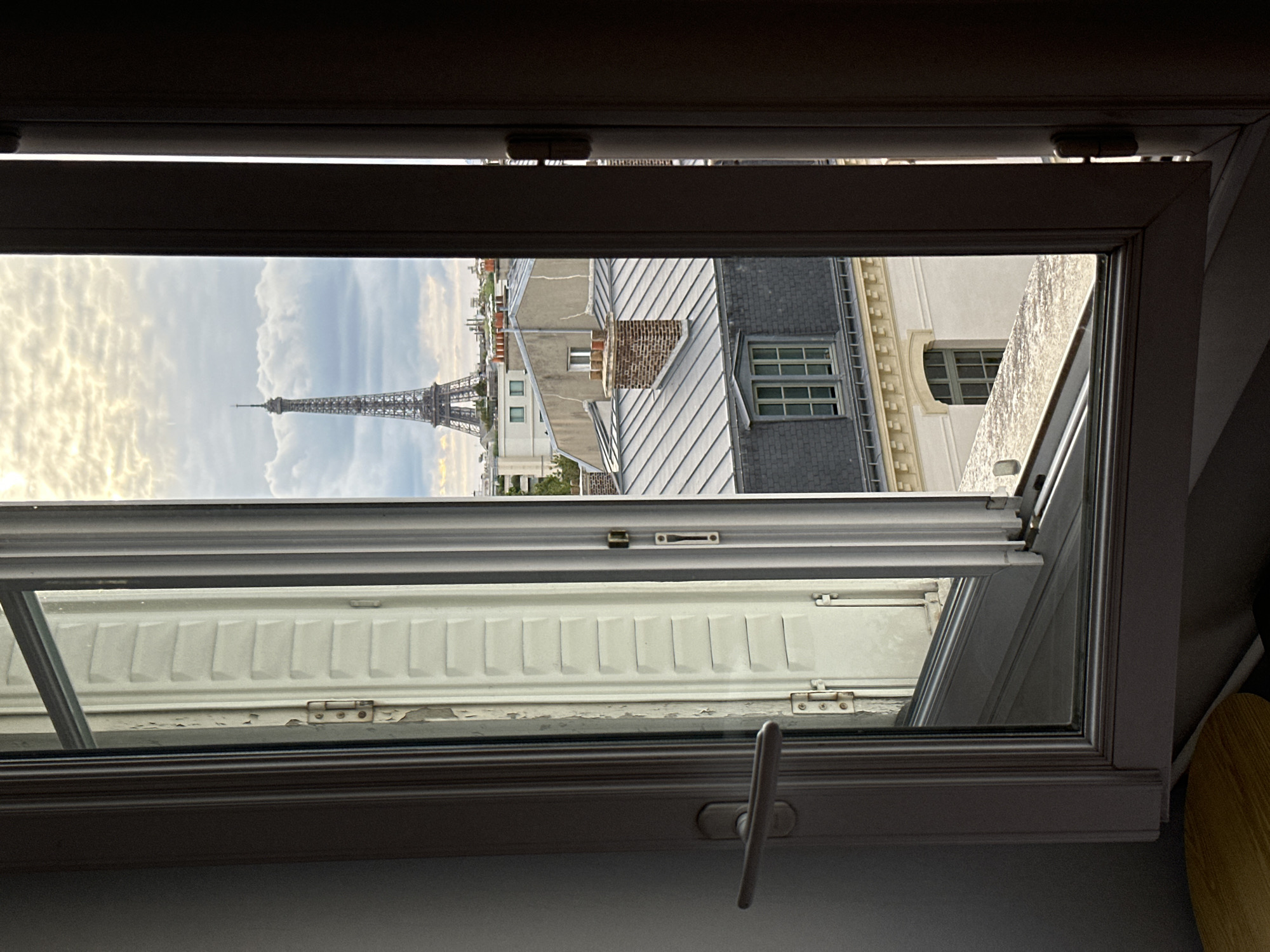 Window views capture Paris rooftops and Eiffel Tower evening scenes