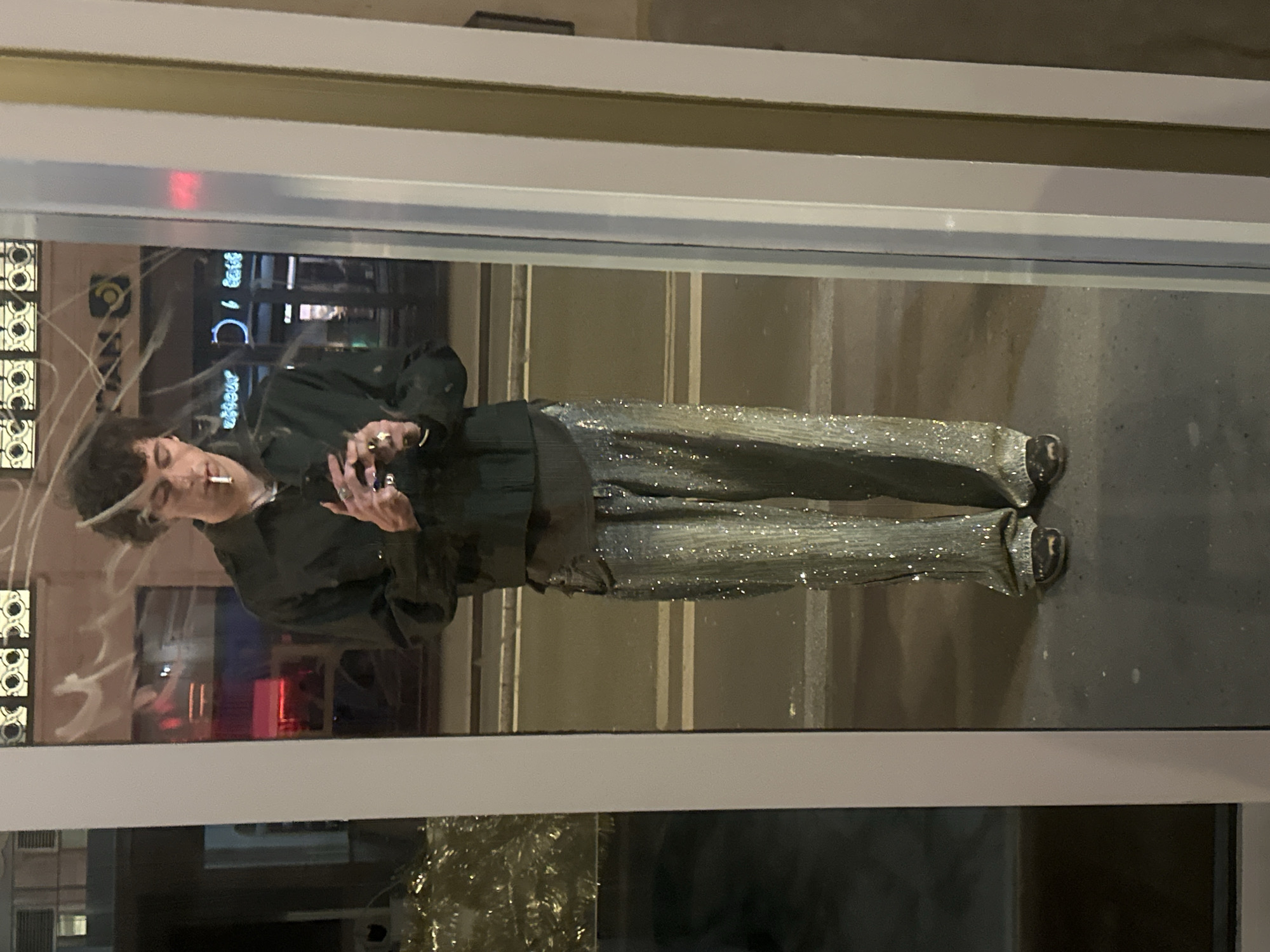 Man smoking cigarette views reflection on Paris street