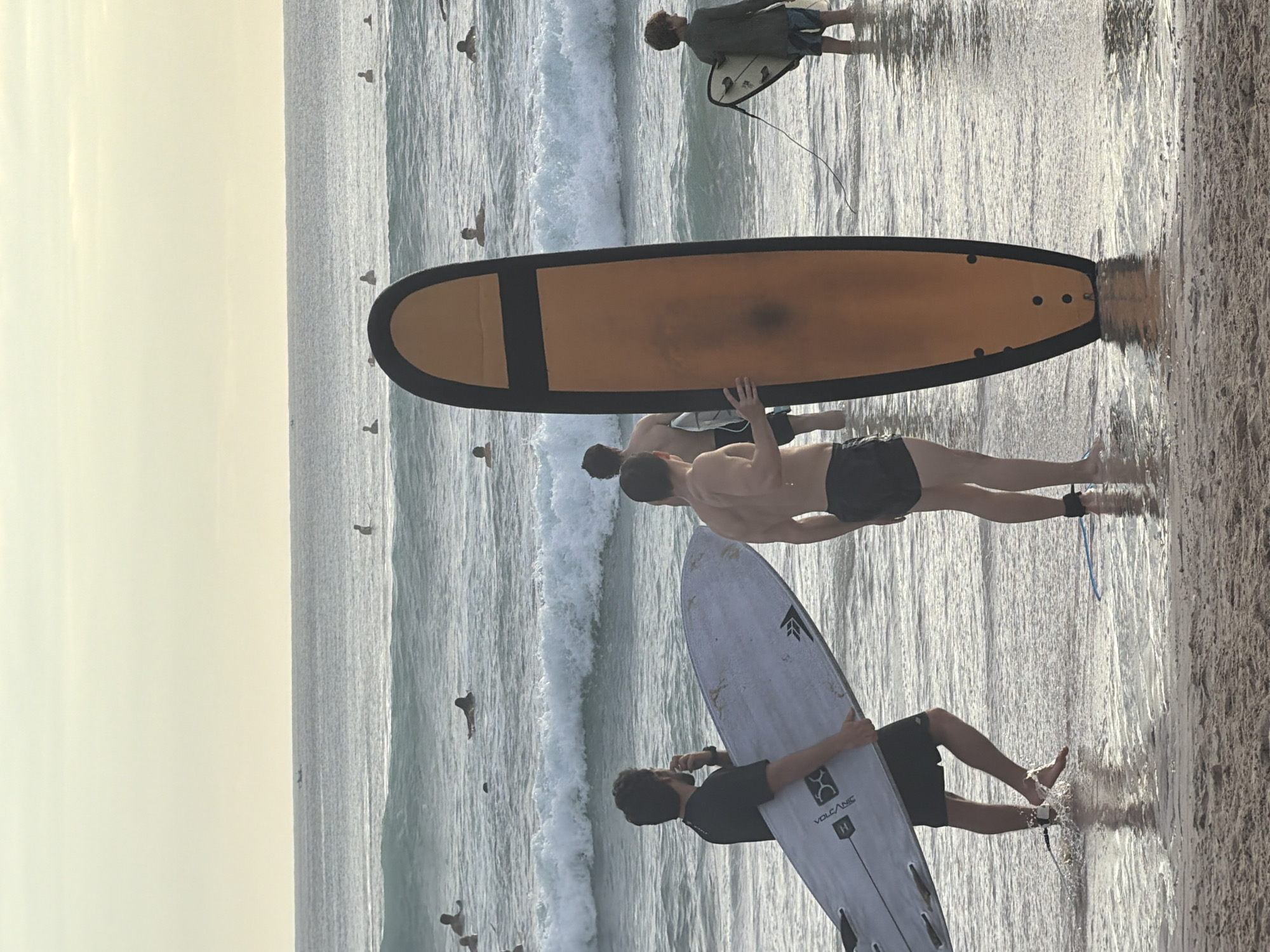 Surfers gather with boards at Kuta Selatan beach