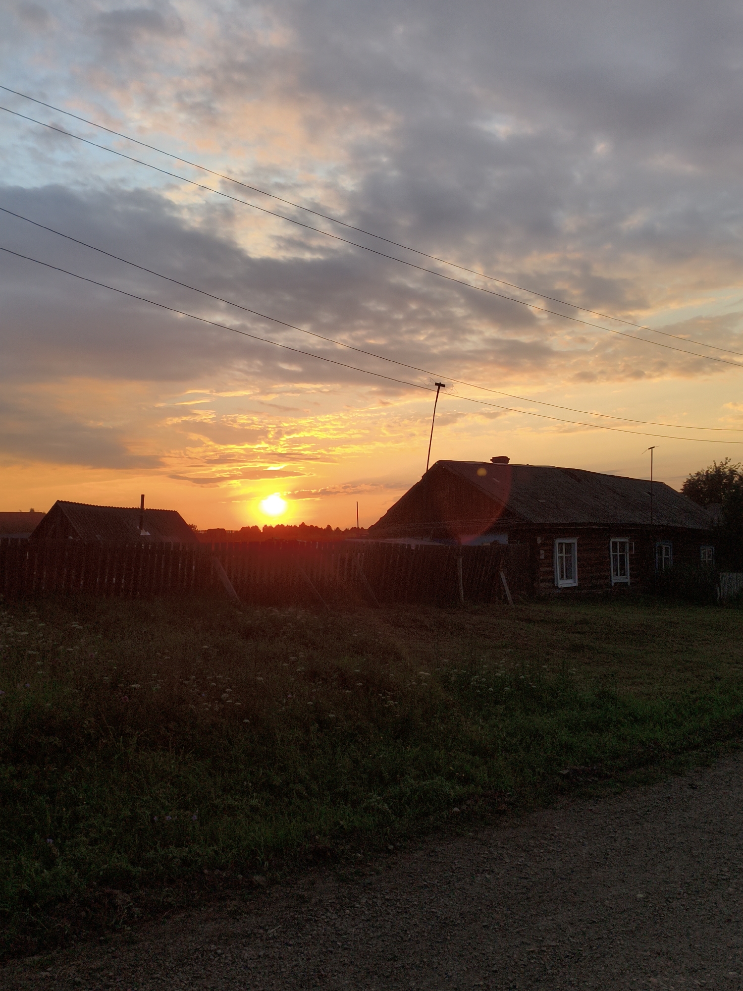 Rural sunset paints the sky in orange and grey