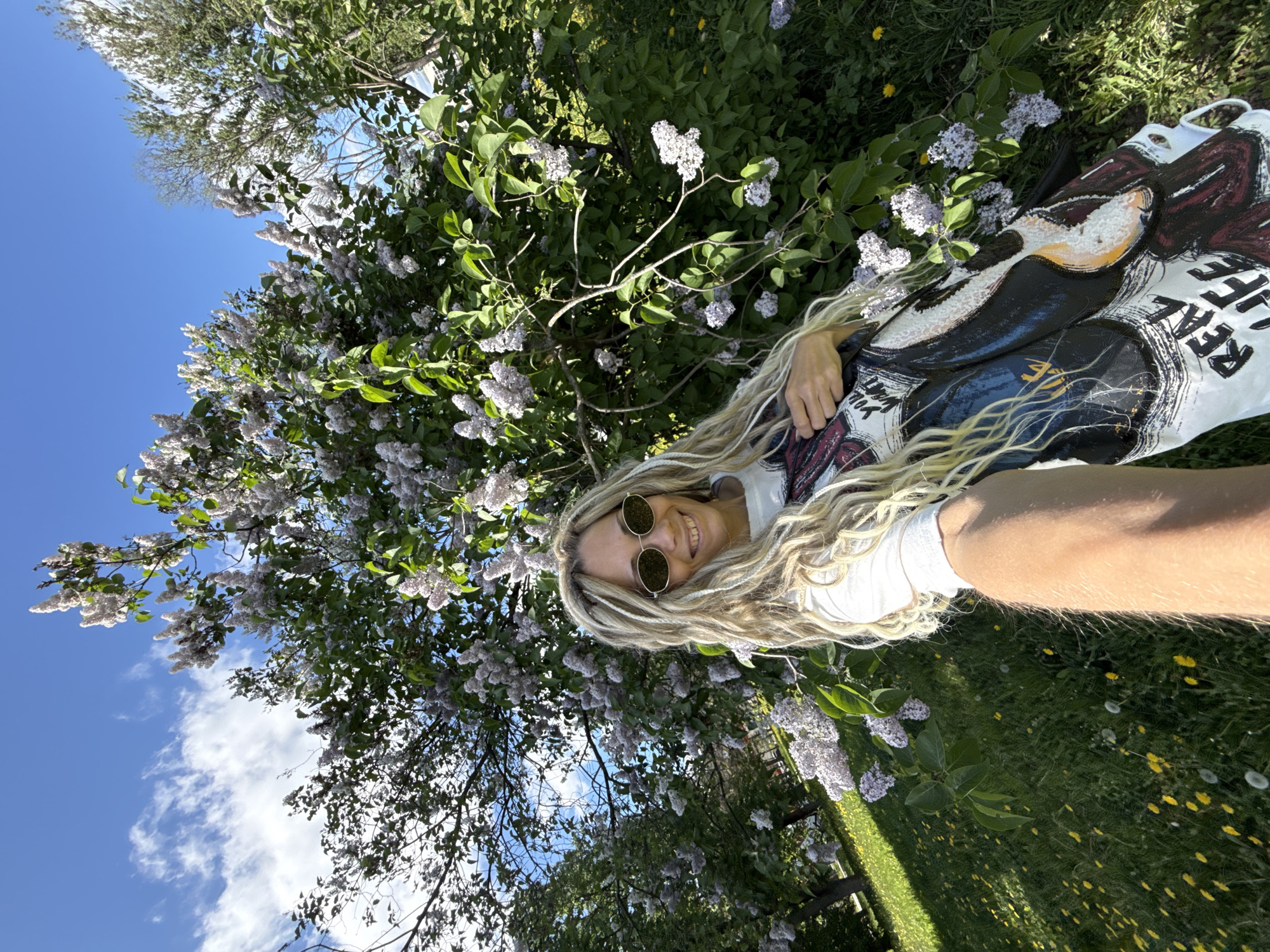 Woman enjoys spring morning among lilac blooms in rural Russia