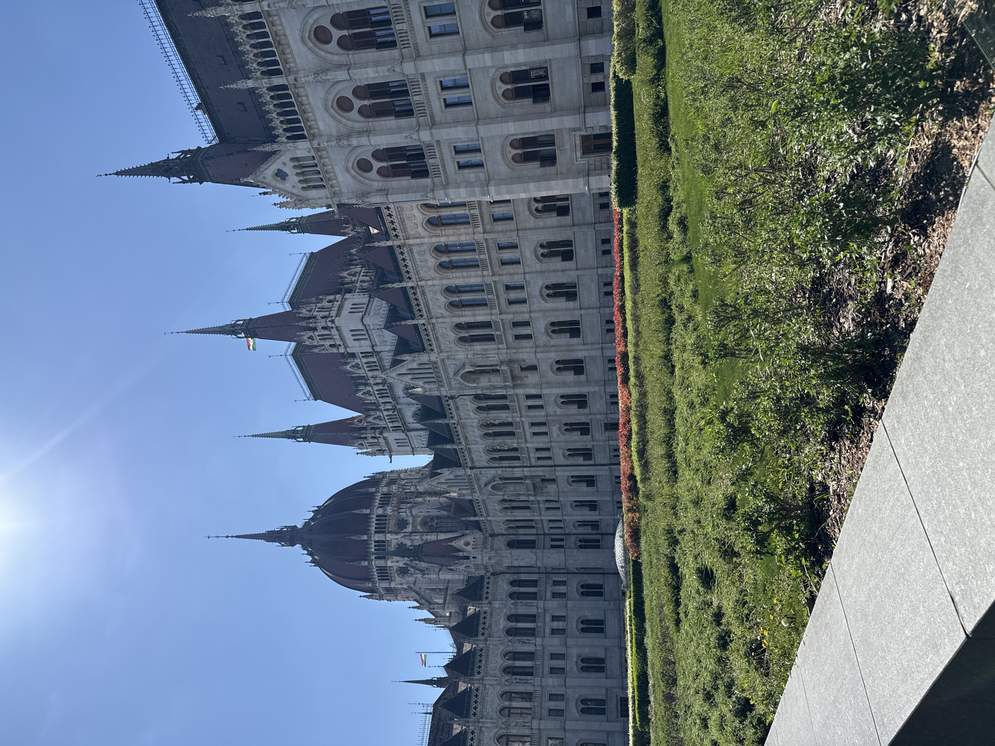 Tourist photographs capture Budapest Parliament Building on sunny afternoon