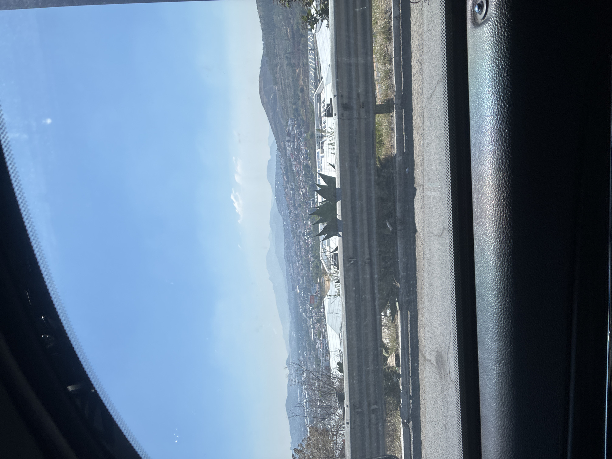 Vehicle travels highway in Ciudad López Mateos under clear skies