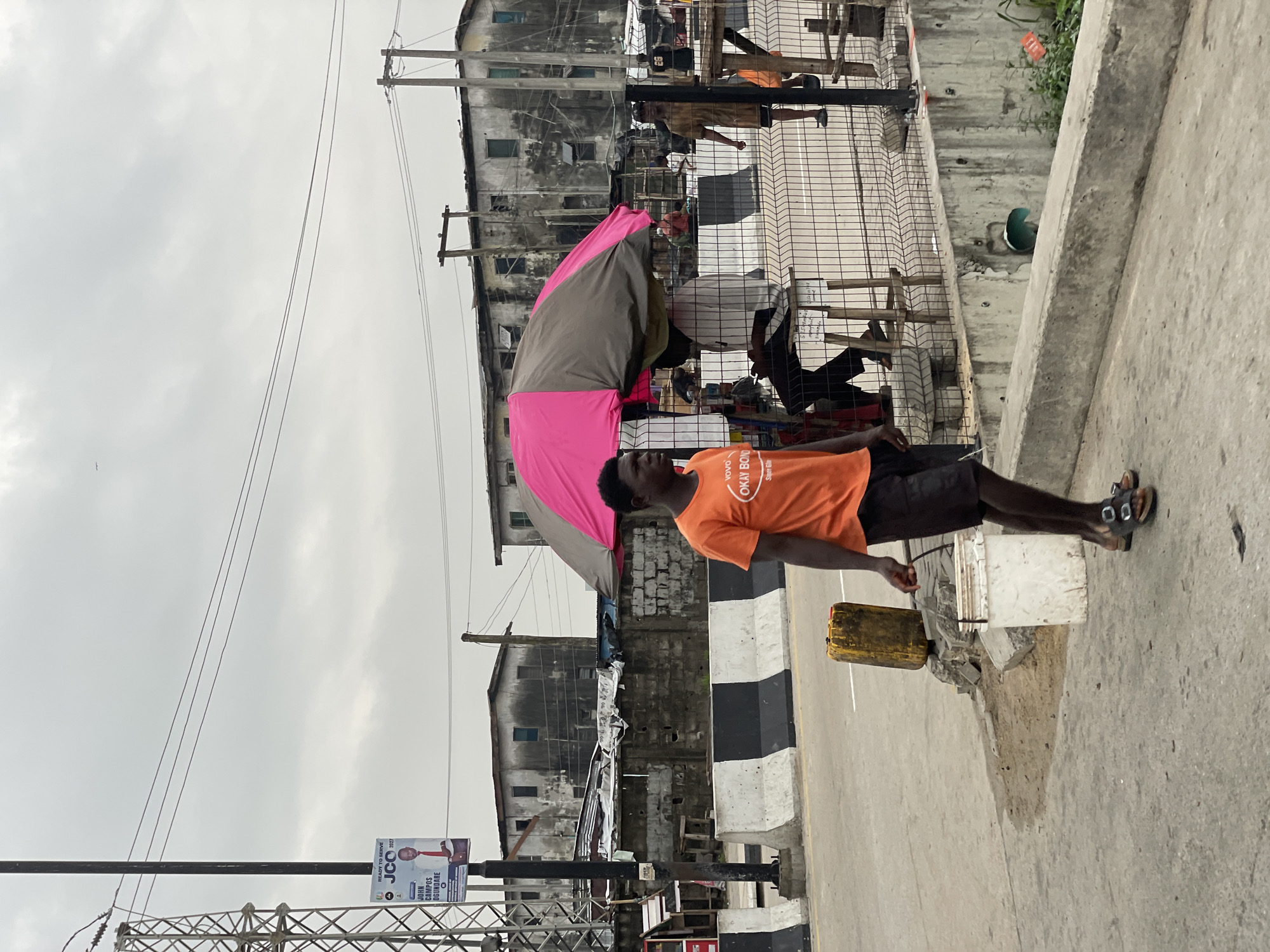 Street activity and church signage on a cloudy Igboefon morning