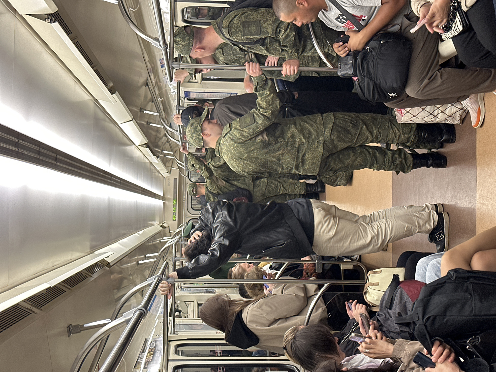 Civilians and military personnel ride the Saint Petersburg Metro together