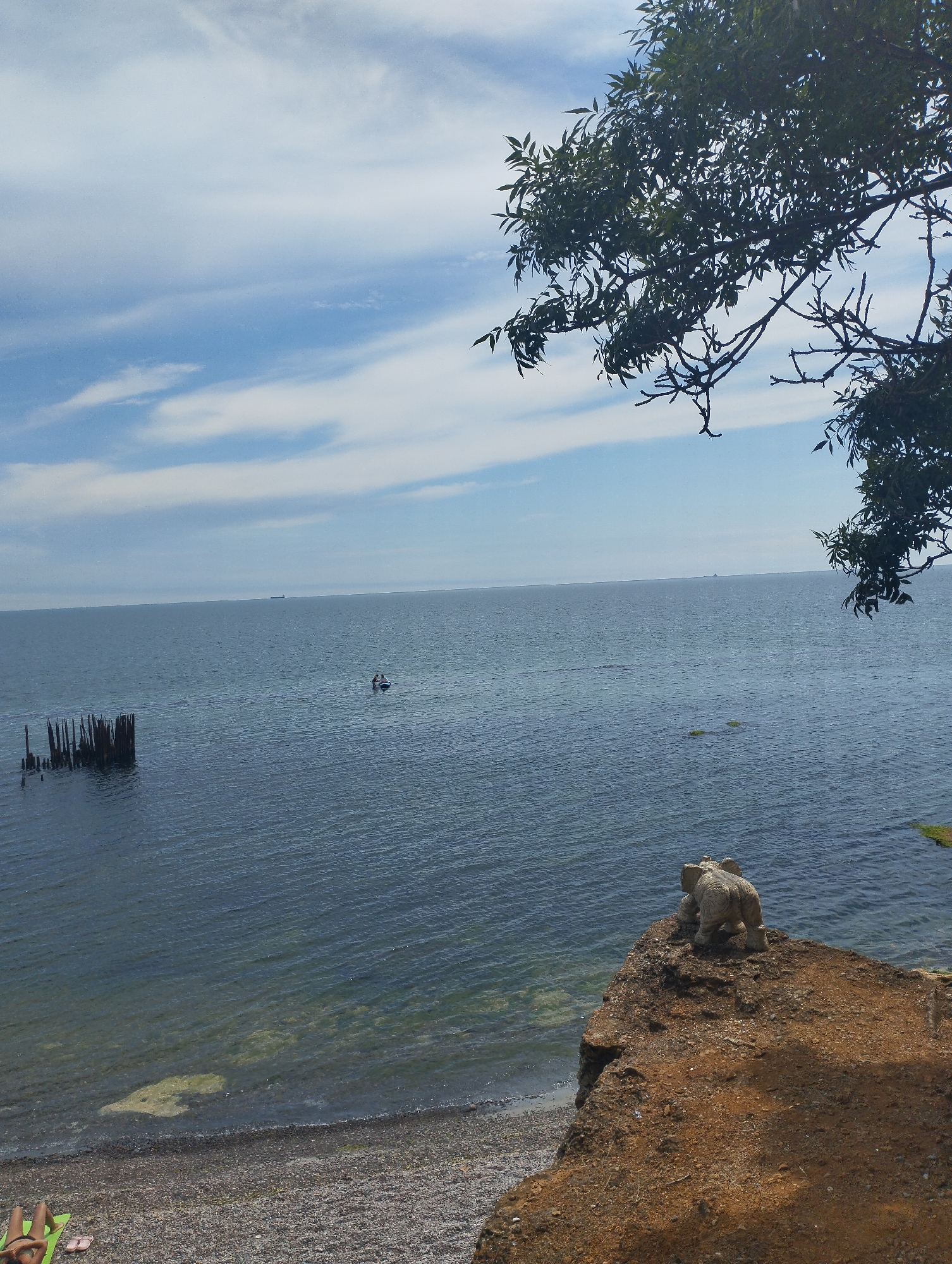 A relaxed day out on the water, beach and paddleboard in view.