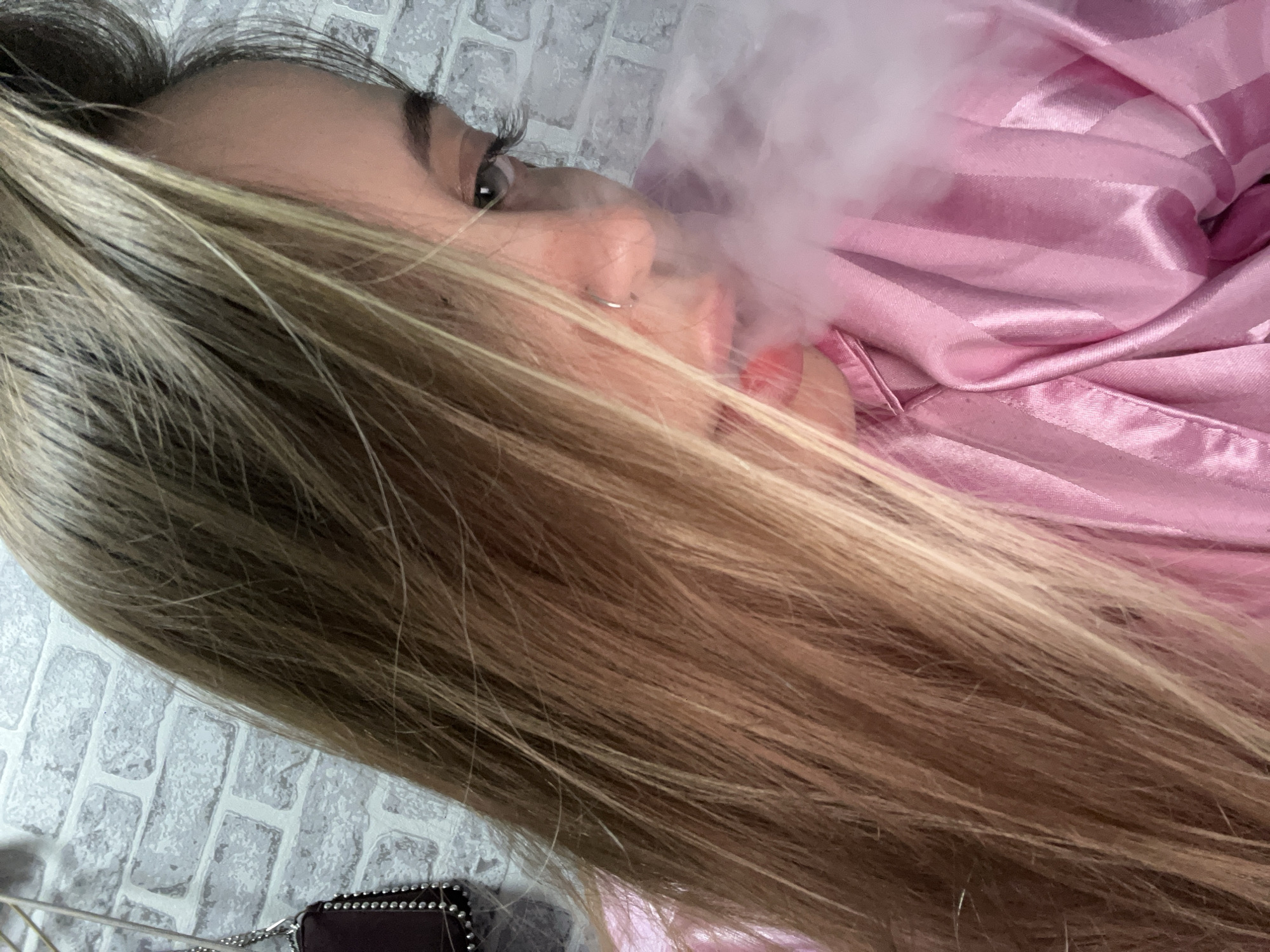 Person vaping while lying on brick surface in Russia