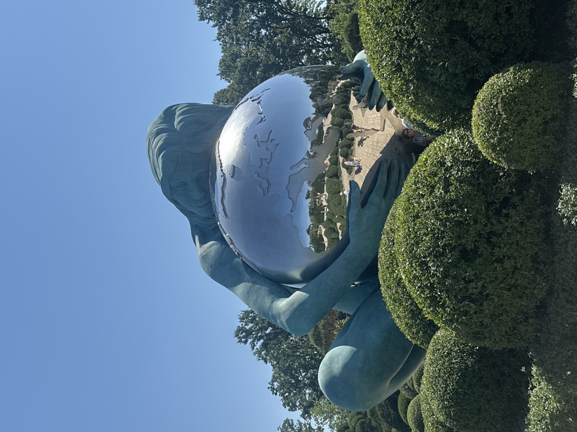 Teal globe-holding sculpture in Krasnodar's public space