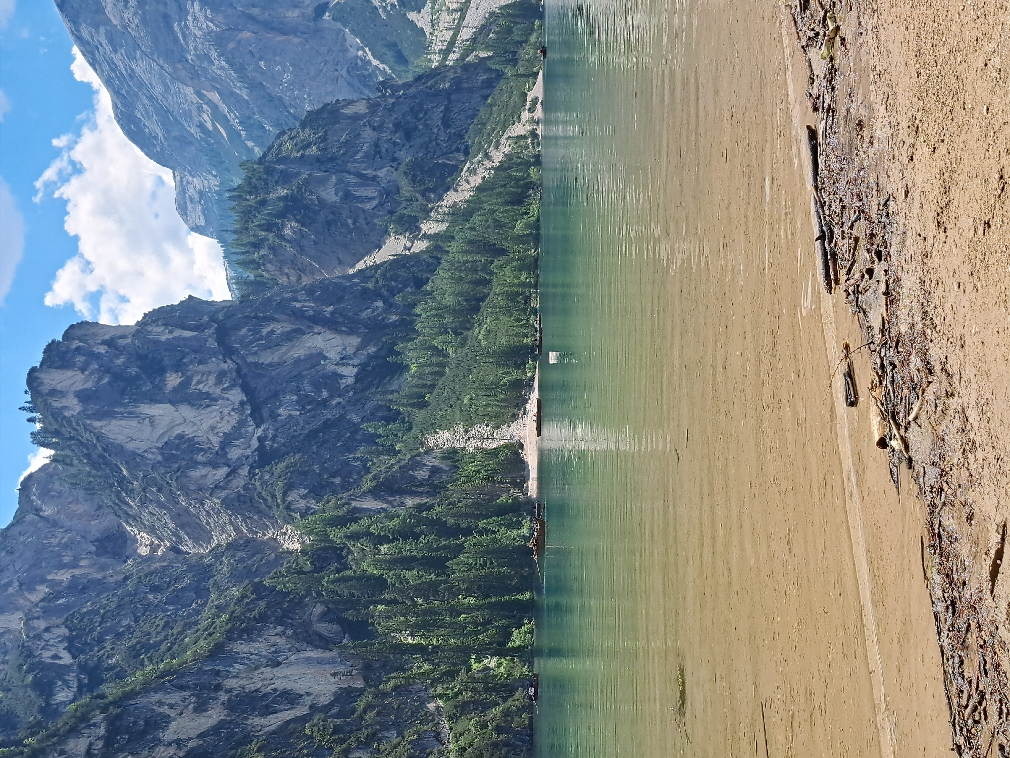 Alpine lake day: clear water, rowboats, stone lodges, mountain backdrop