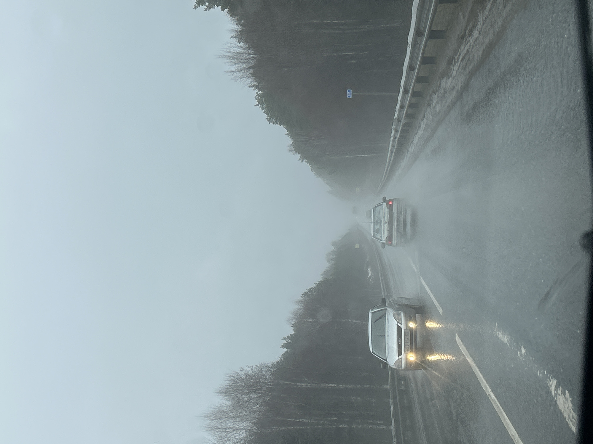 Vehicles travel wet highway during rainy day in Chaykovsky