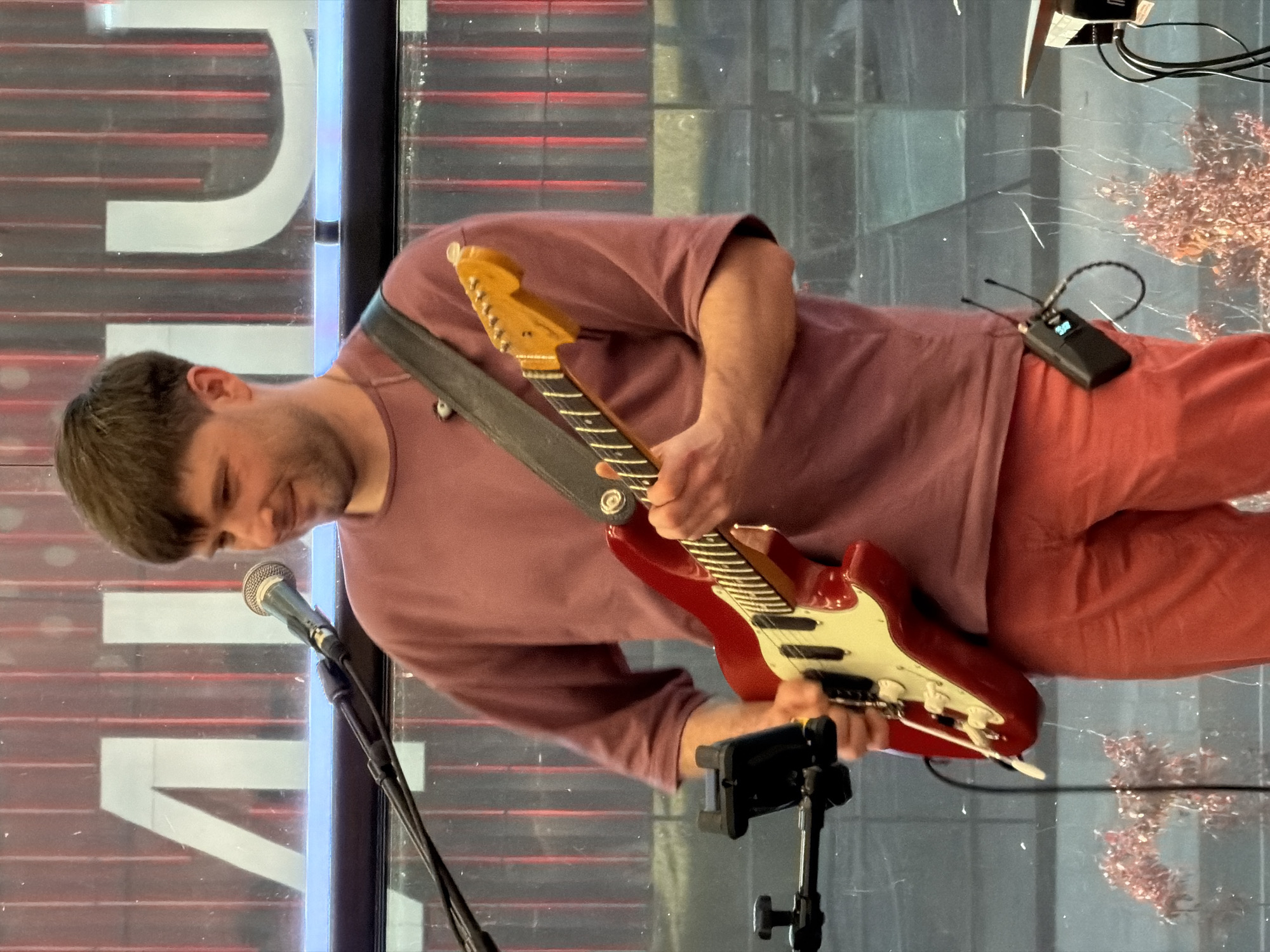 Guitarist performs indoors near decorative window in Moscow