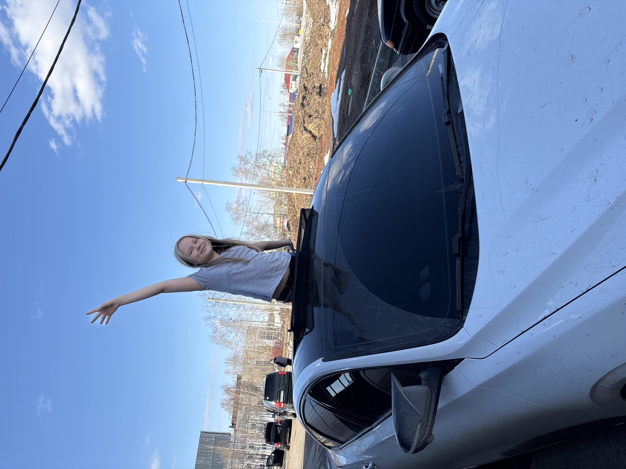 Woman poses through sunroof during car wash visit in Izhevsk