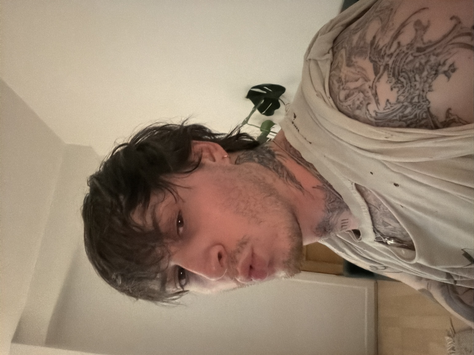 Tattooed selfie with silver cross pendant, London.