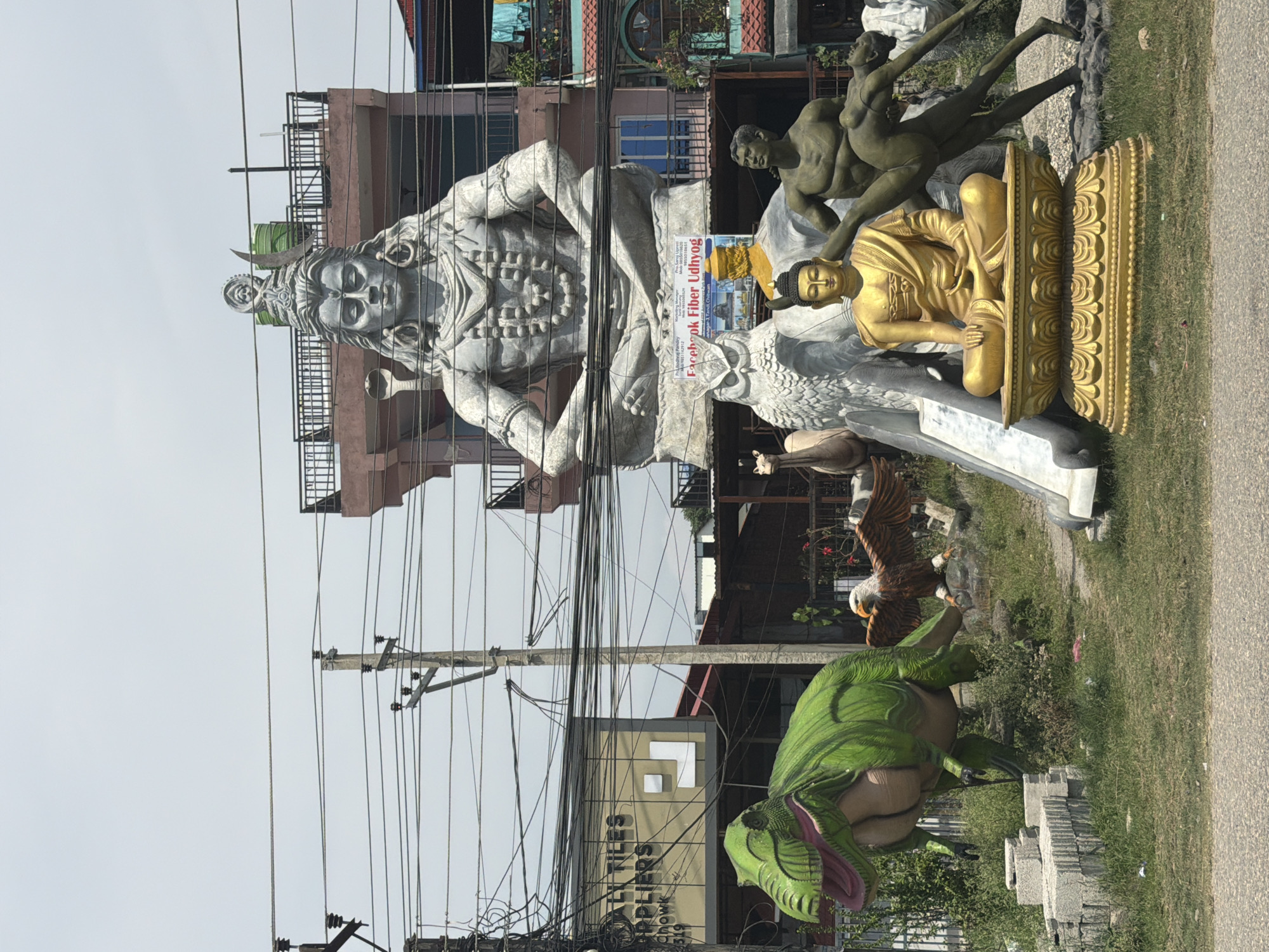 Religious statues including seated Shiva deity displayed roadside in Nepal