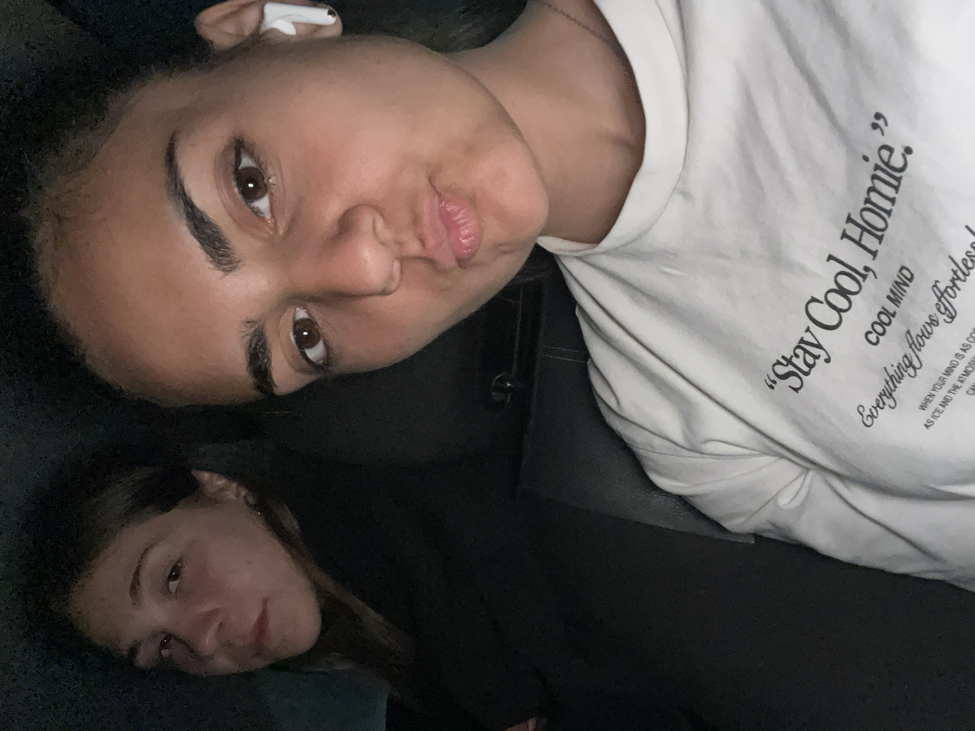 Young women take selfies in car during evening hangout