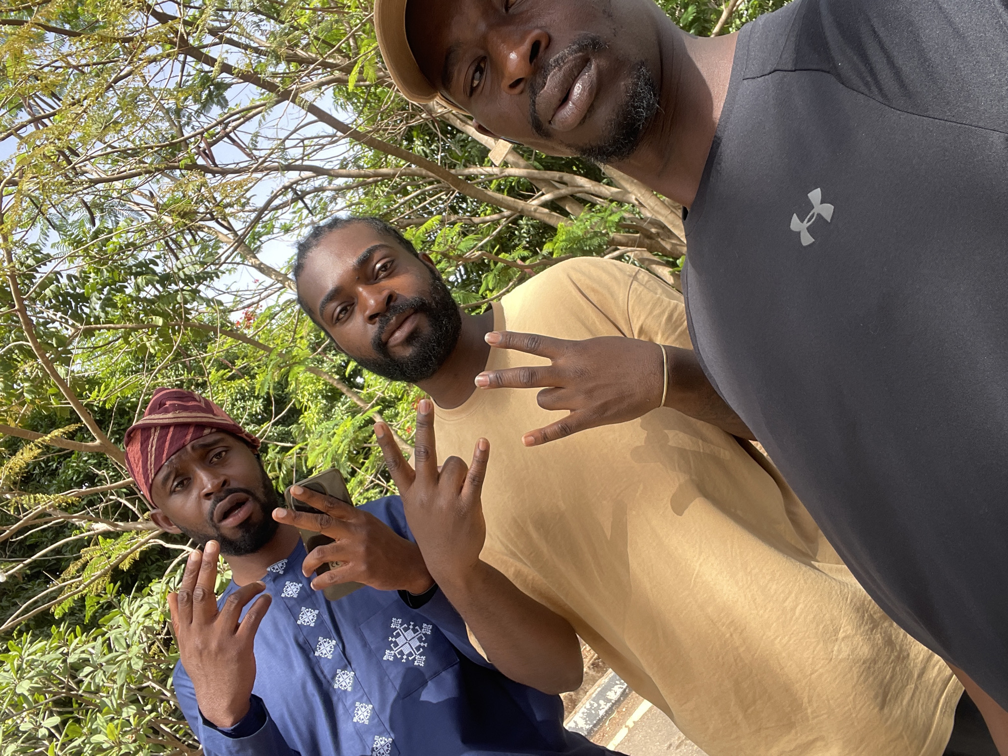 Three men gather outdoors in Jos, Nigeria
