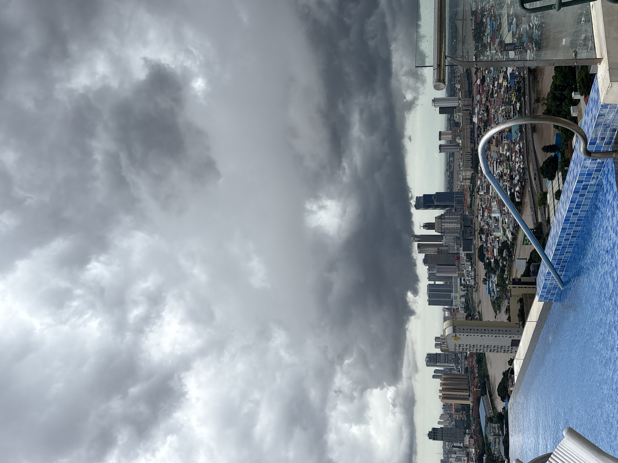 Phnom Penh's riverfront density seen from above under storm clouds
