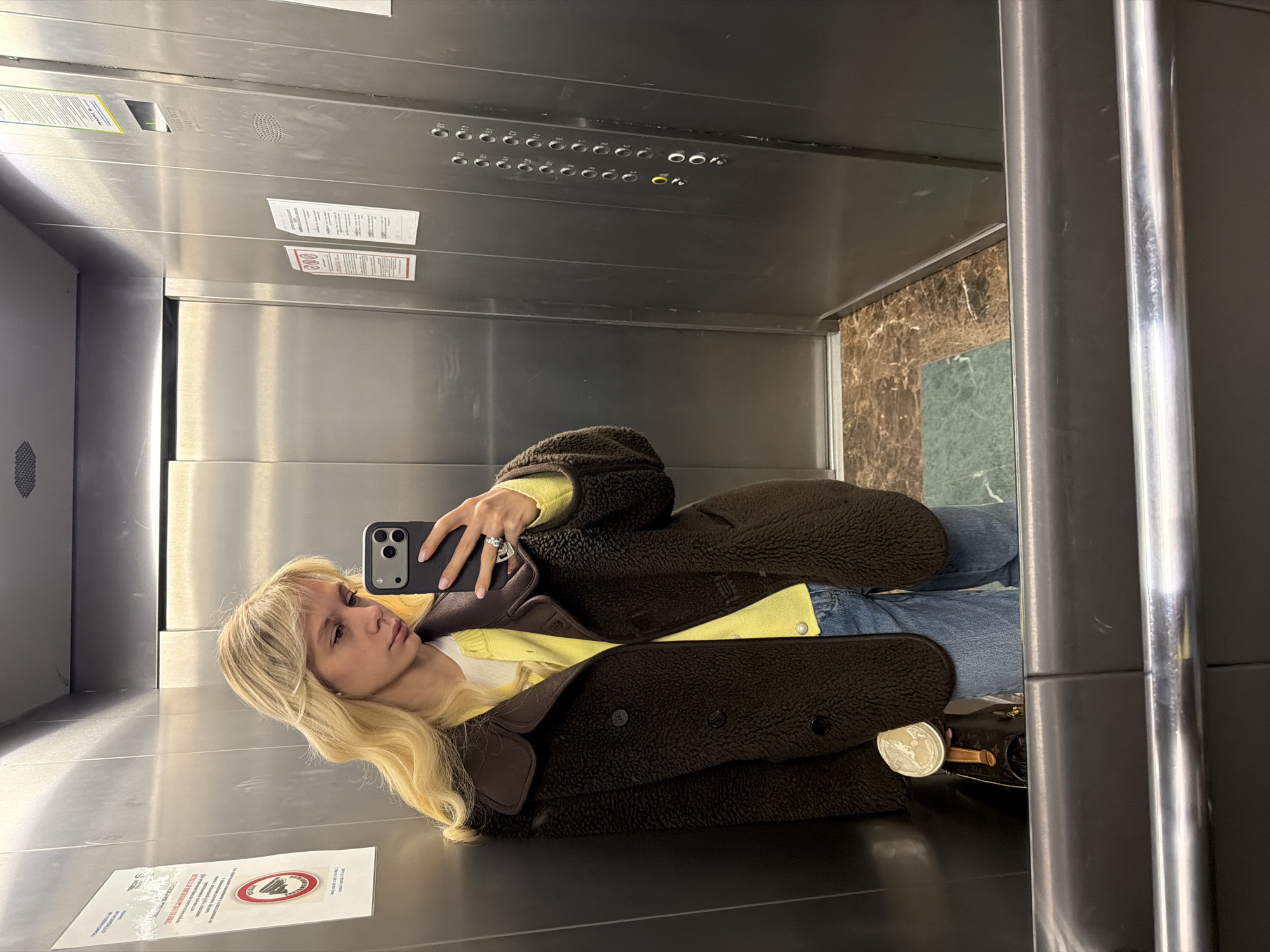 Woman Takes Selfie in Silver Elevator