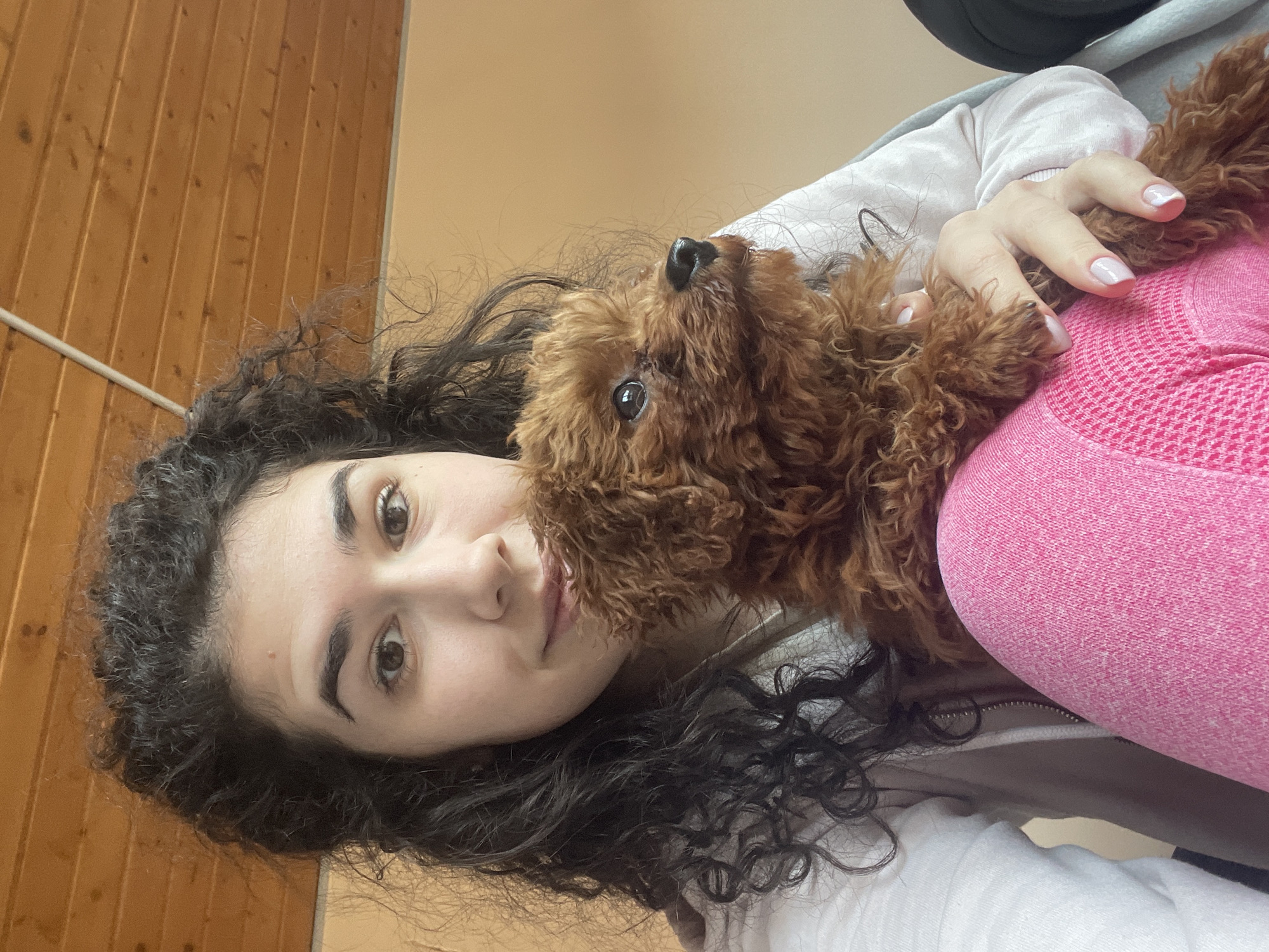 Woman walks poodle in sweater through Sofia garden