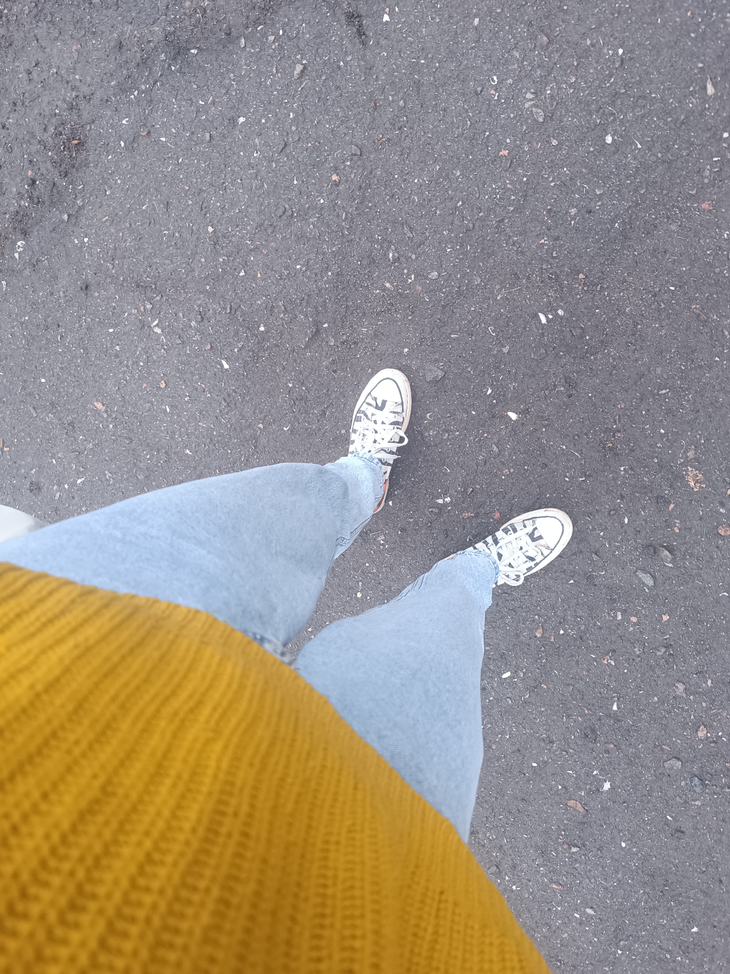 Person in jeans and sneakers photographed on Odesa street