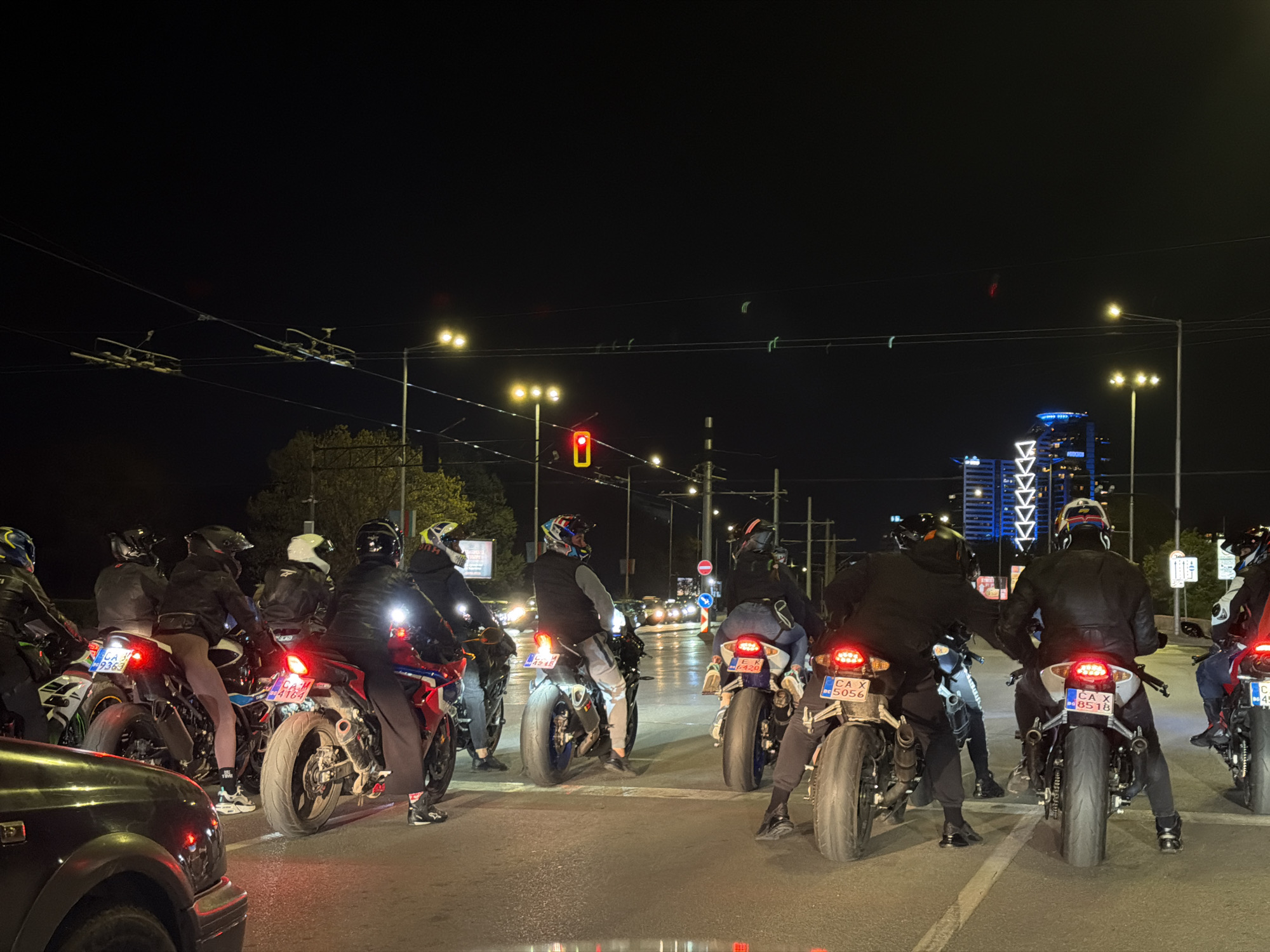 Motorcycle group stops at Sofia intersection during evening hours