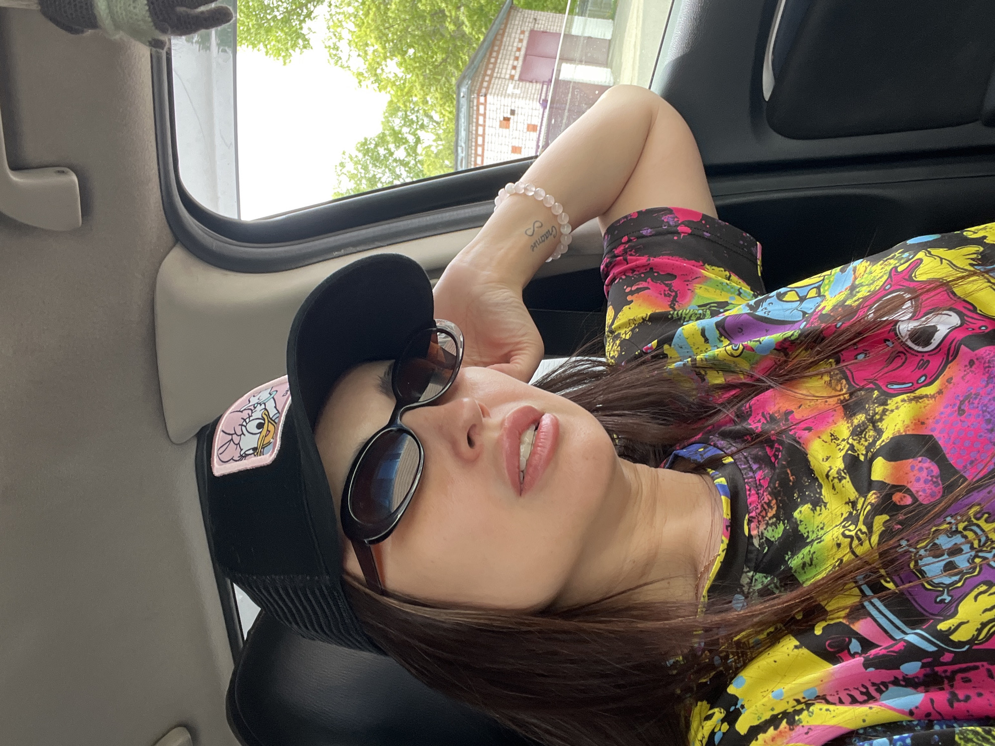 Woman rests in car with open sunroof during early morning