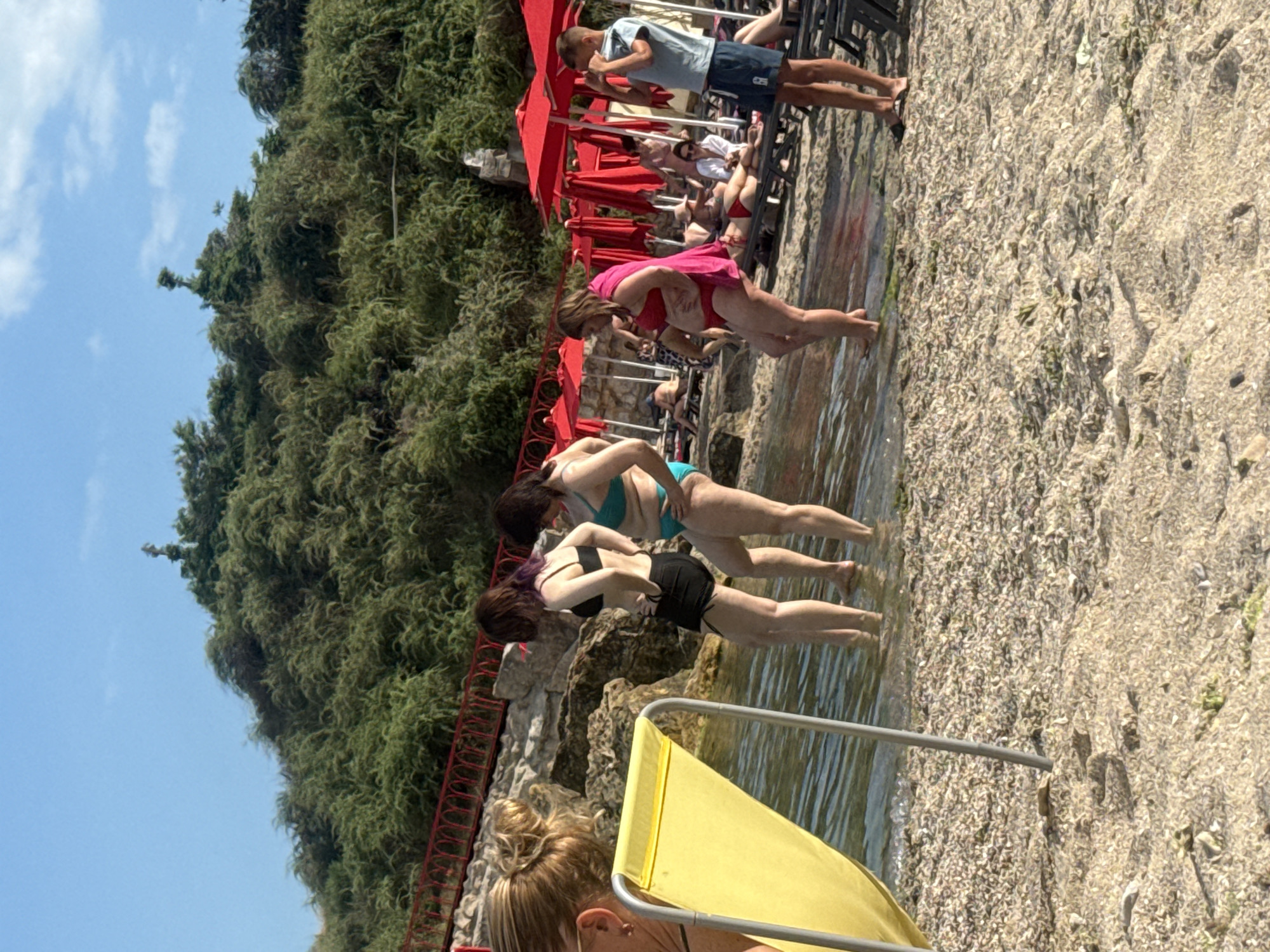 Sunny afternoon at an Odesa beach with umbrellas and rocky coastline
