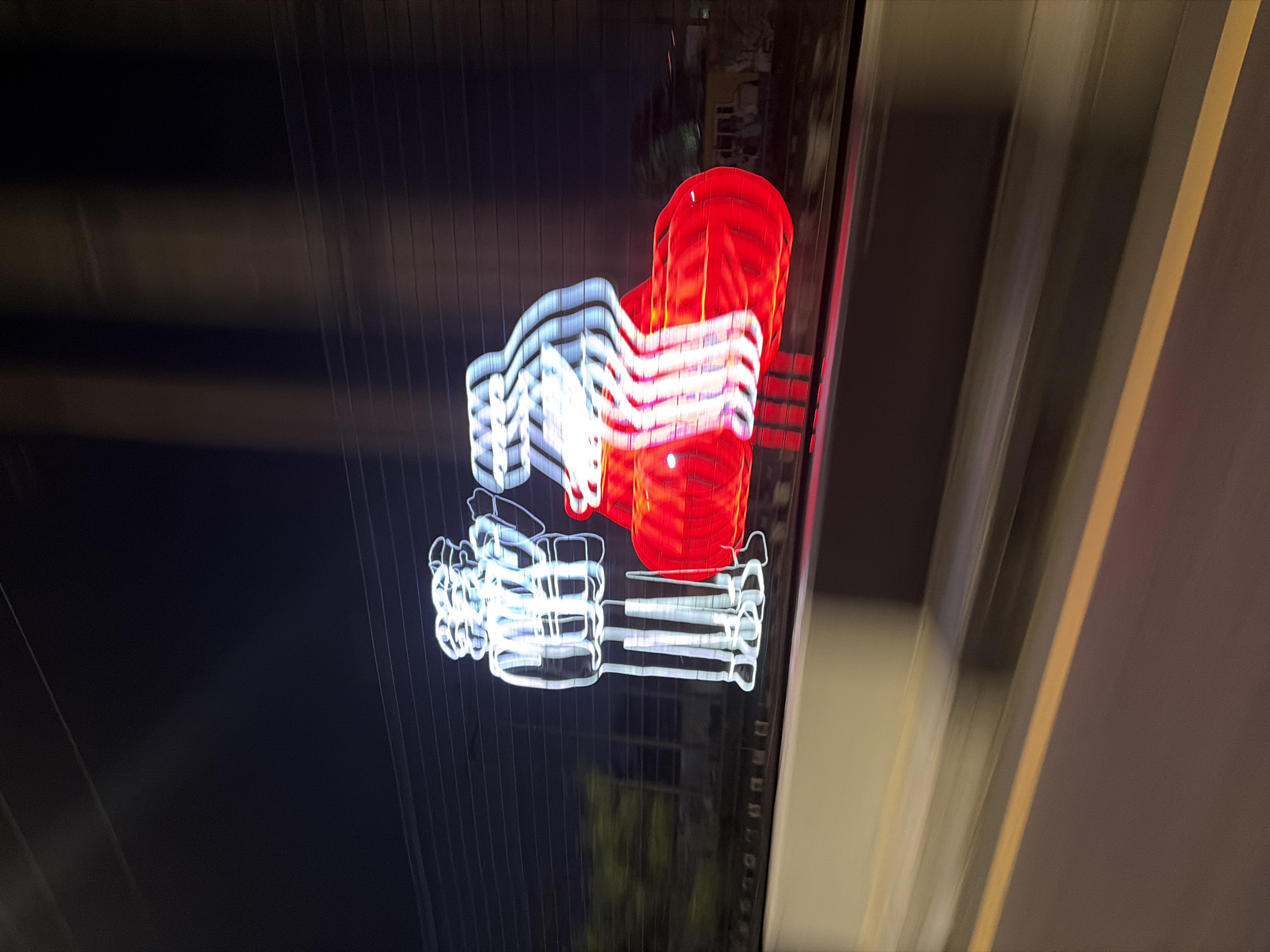 Blurred neon sign photographed from moving vehicle in Lagos