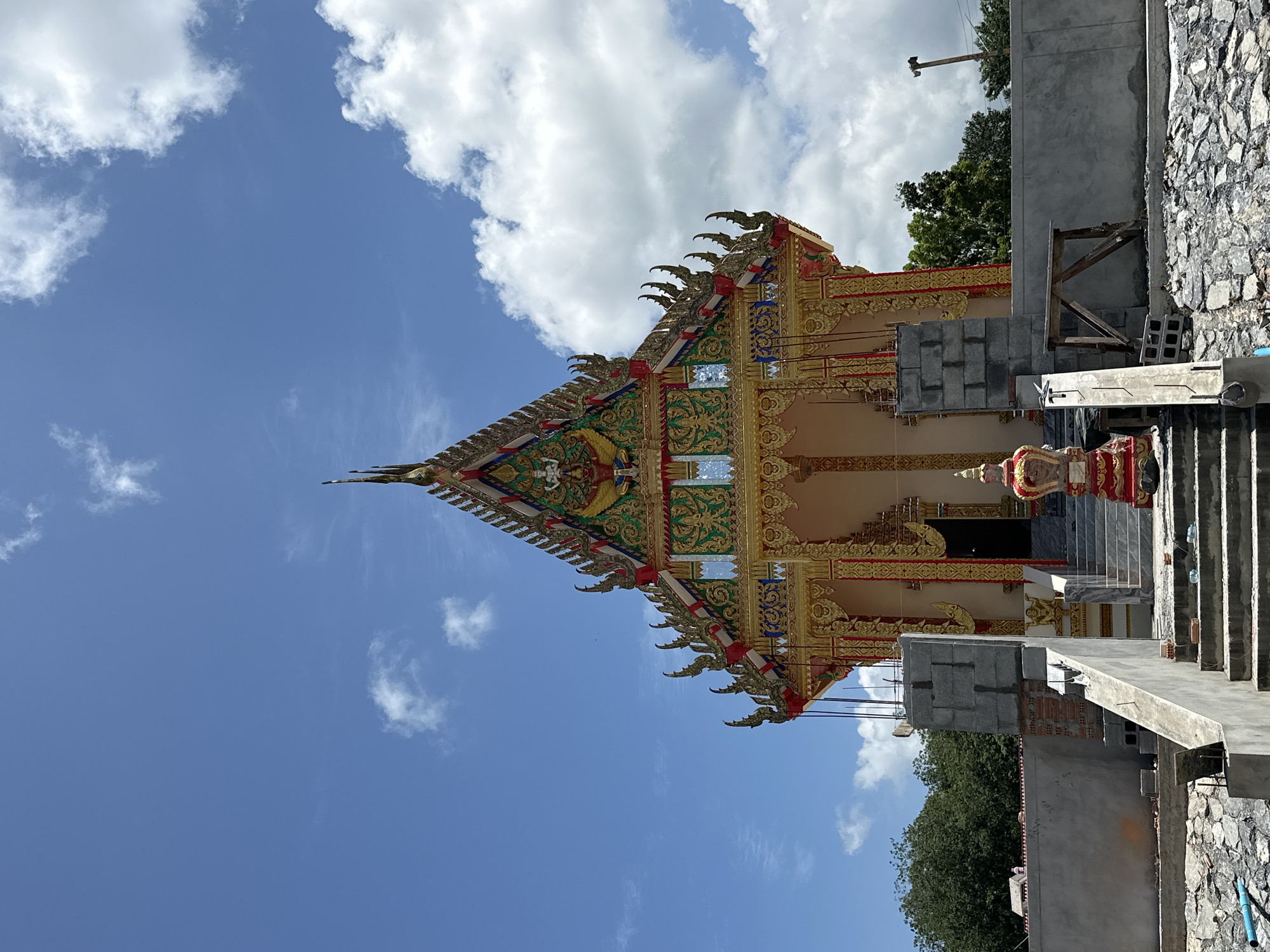 Buddhist temple construction beside a limestone cliff in Thung Yai
