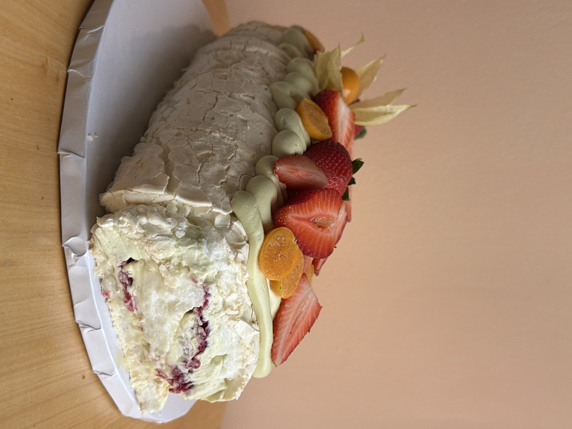 Baker prepares decorated meringue roulade cake in Tel Aviv kitchen