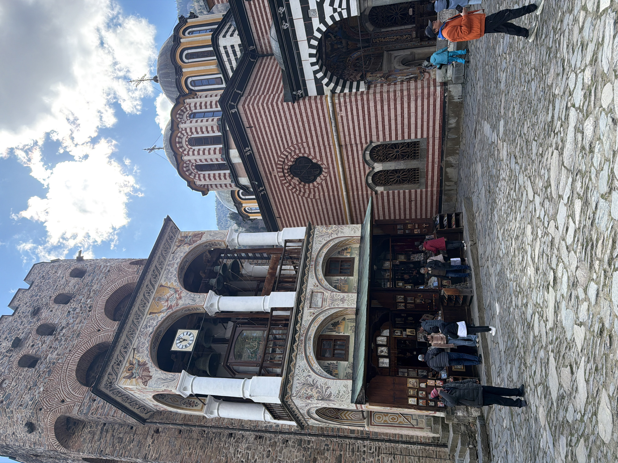 Morning visitors gather at Bulgaria's historic Rila Monastery courtyard