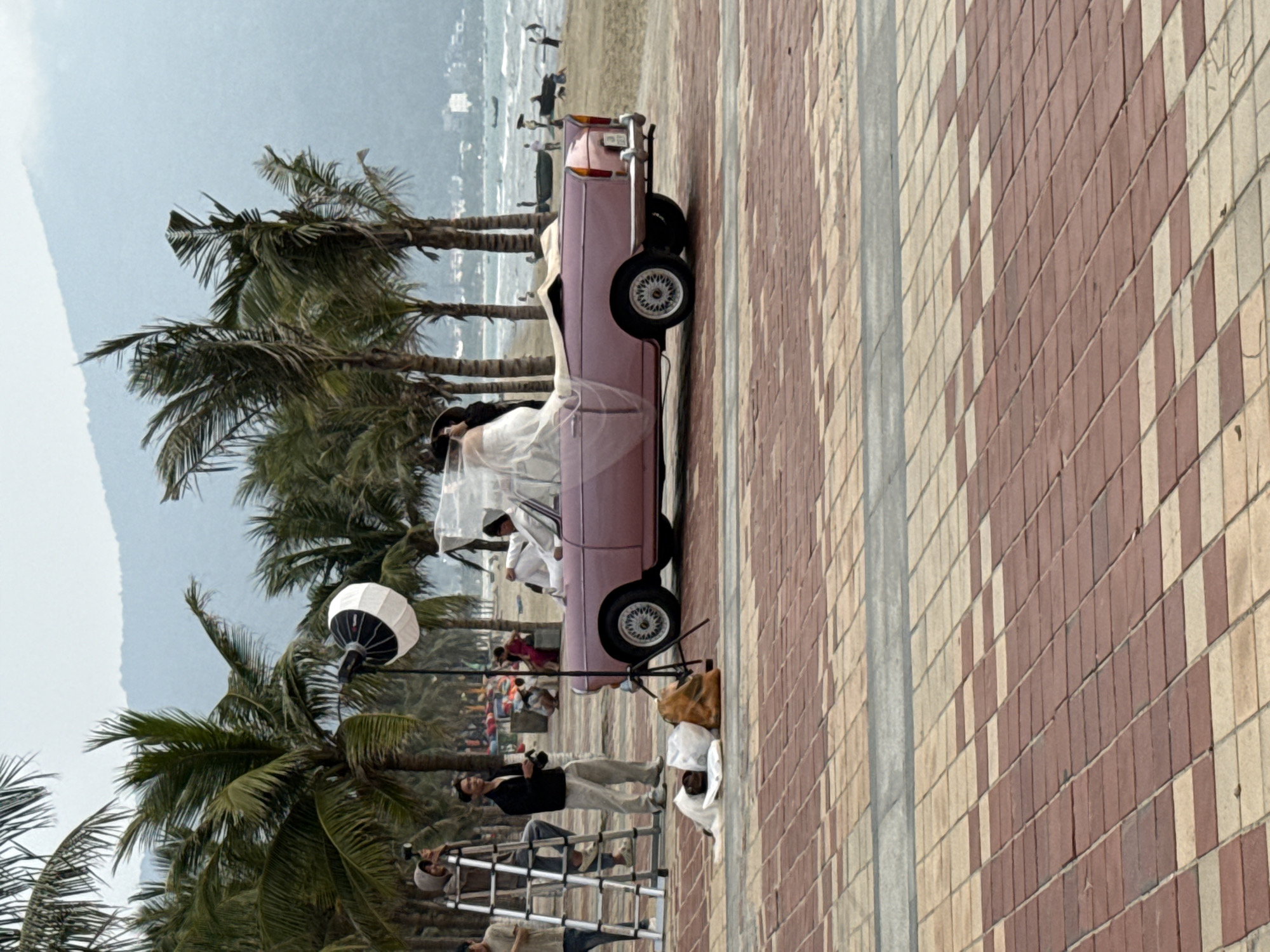 Professional photoshoot with vintage pink convertible at Da Nang beach
