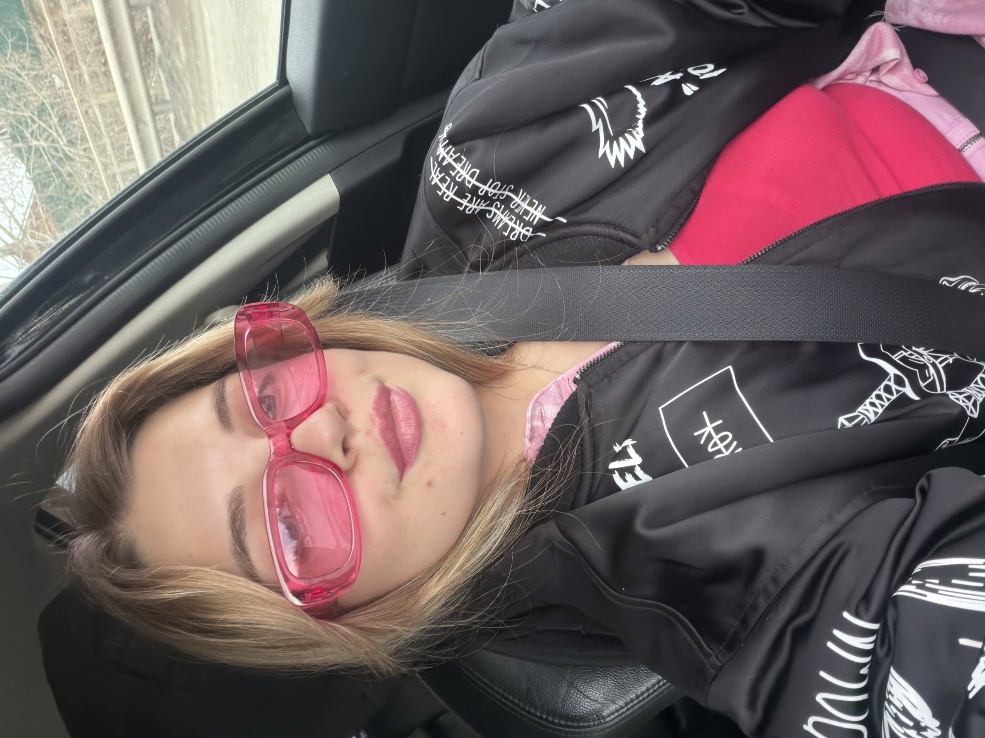 Woman in pink sunglasses spotted in car passenger seat