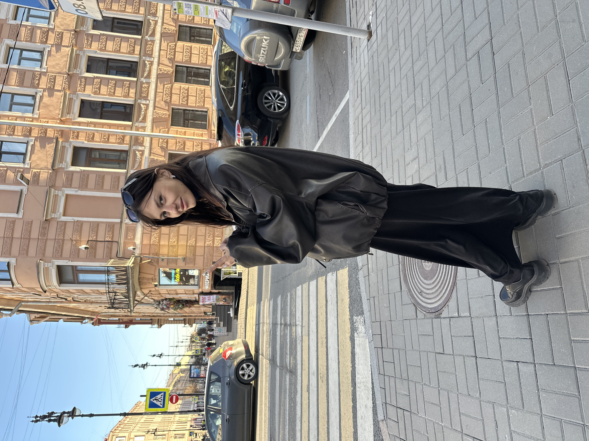 Woman photographed on Saint Petersburg sidewalk during sunny afternoon