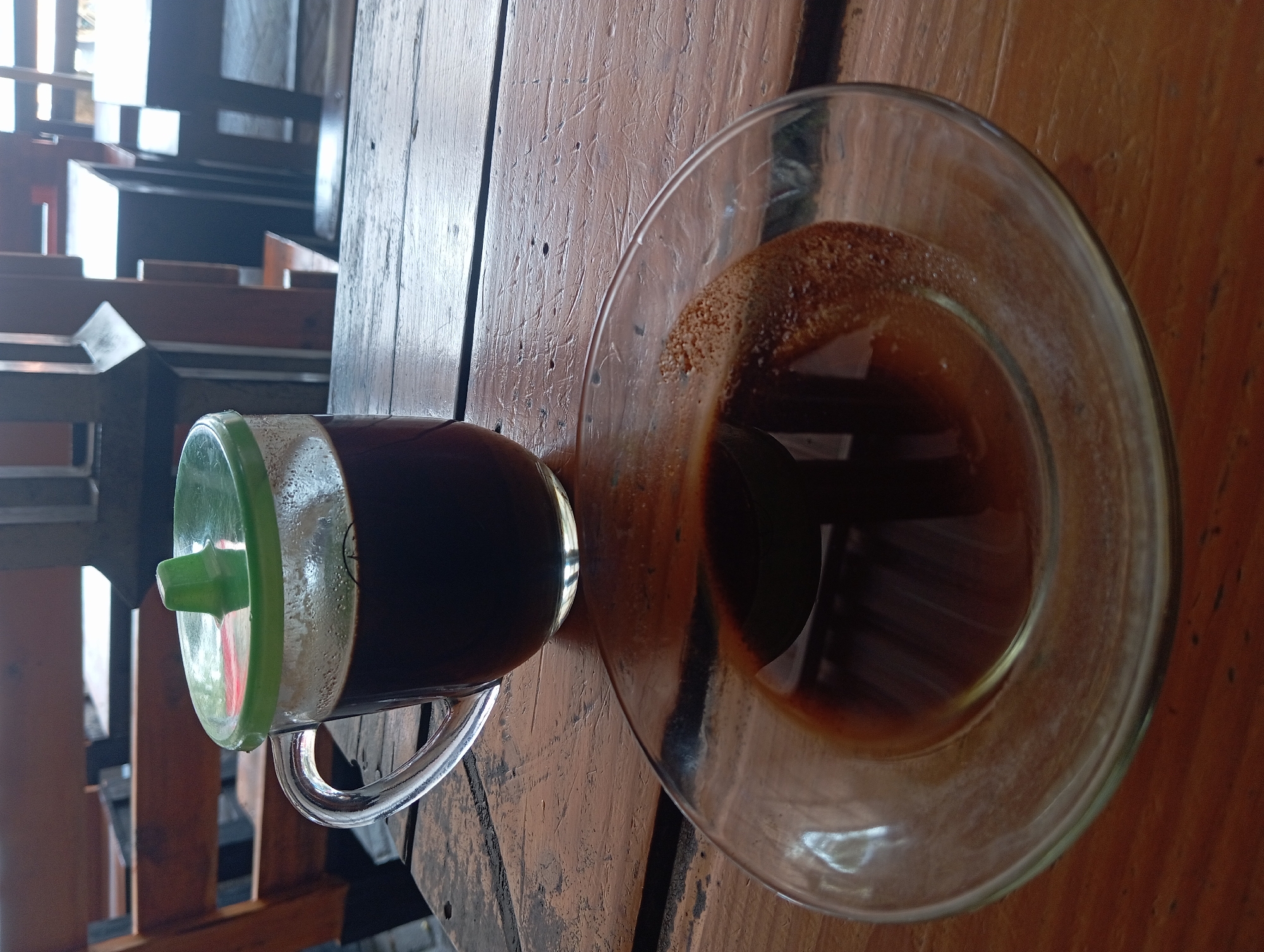 Glass coffee mug on a wooden table in low light