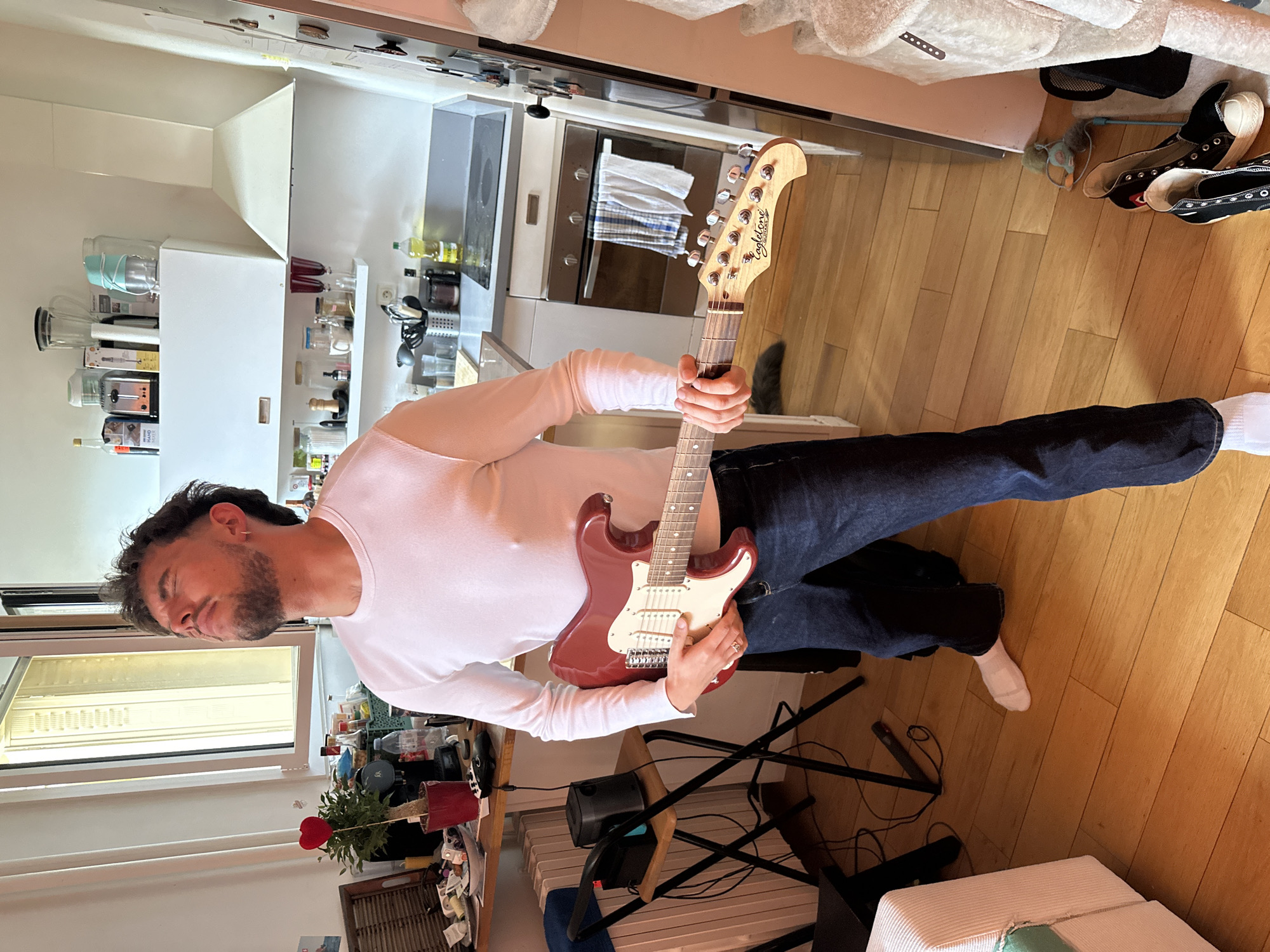 Man plays electric guitar at home in Paris