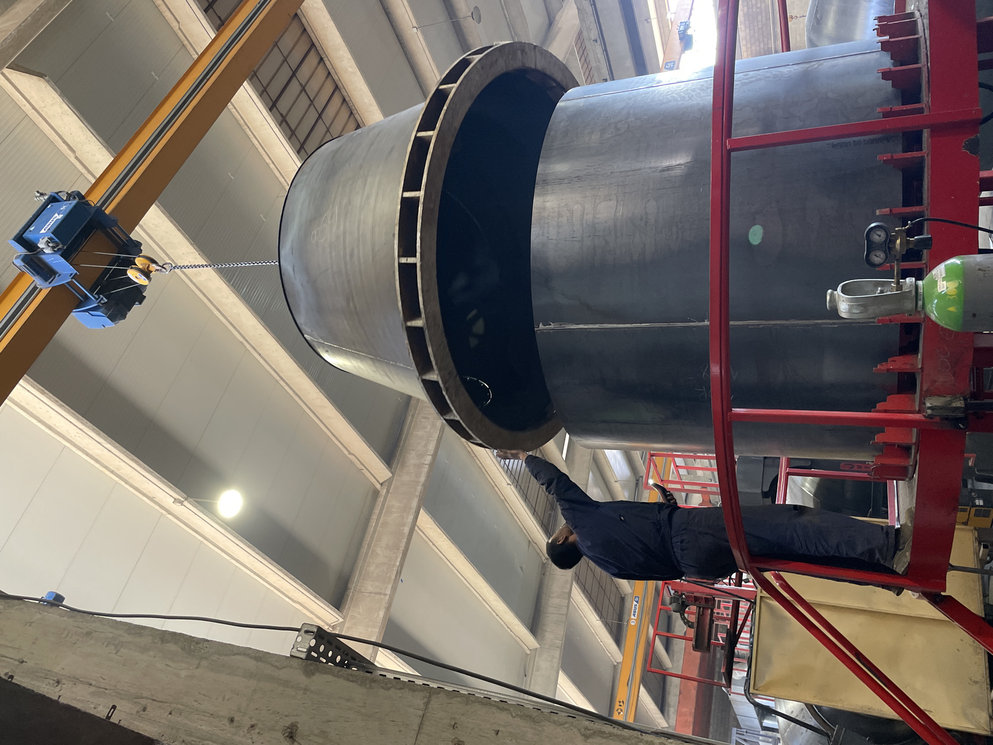Crane moves large metal cylinder in Montenegro industrial facility