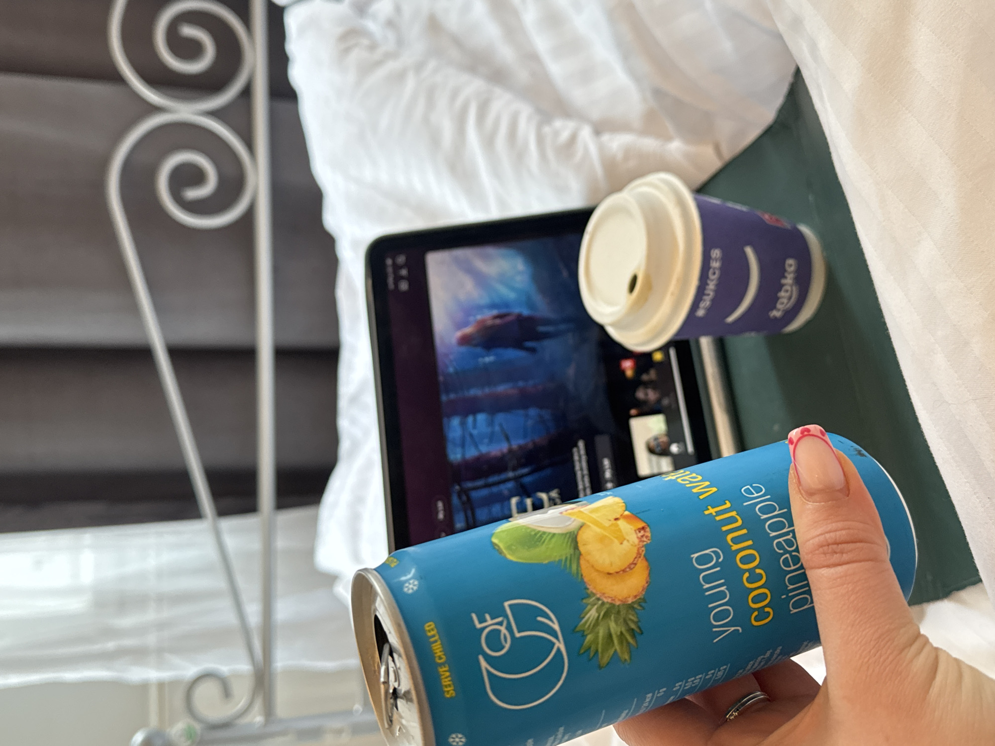 Person enjoys coconut water drink with tablet in Krakow