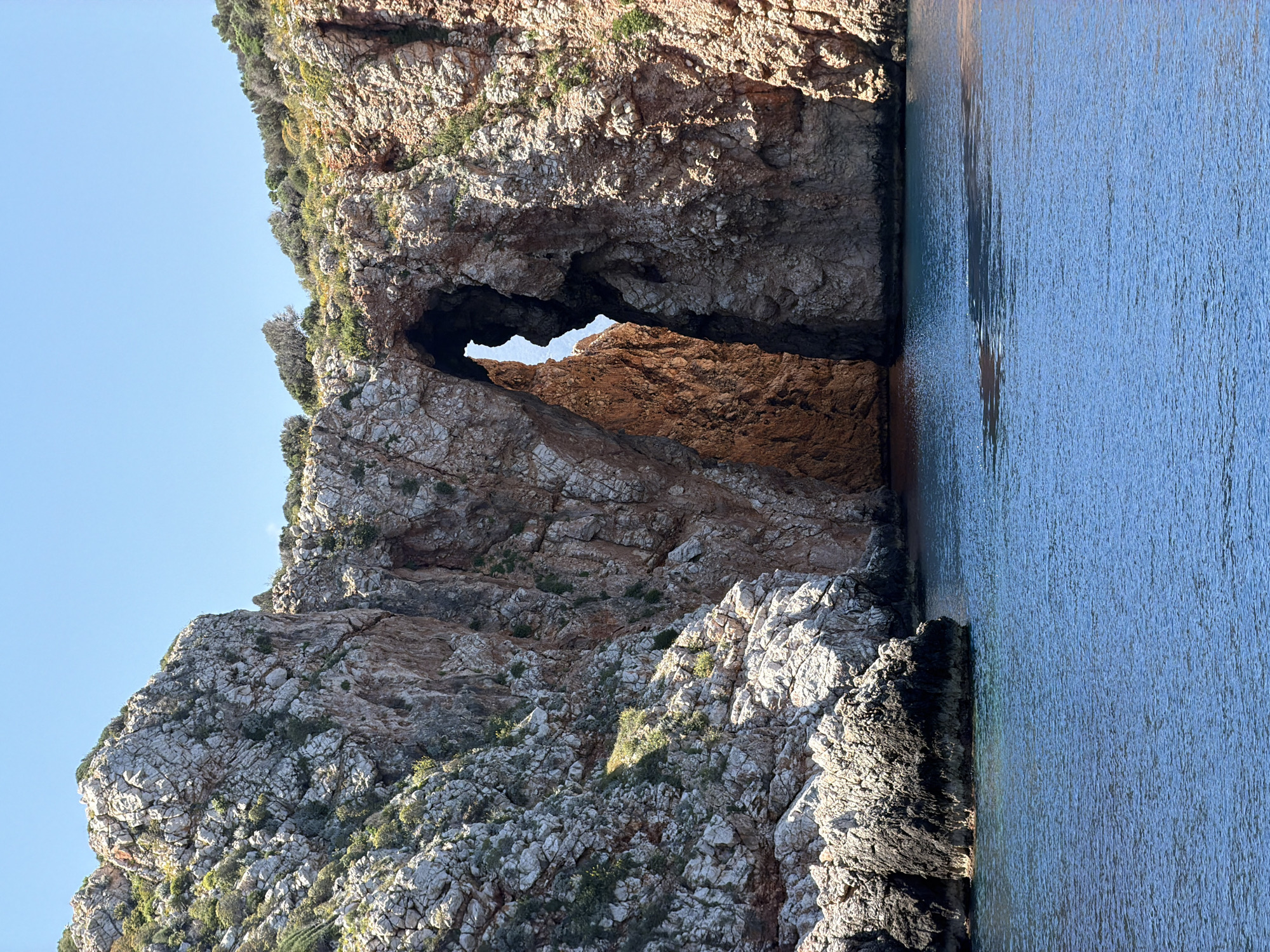 Turkish coastal boat tour navigates dramatic cliffs and natural arches